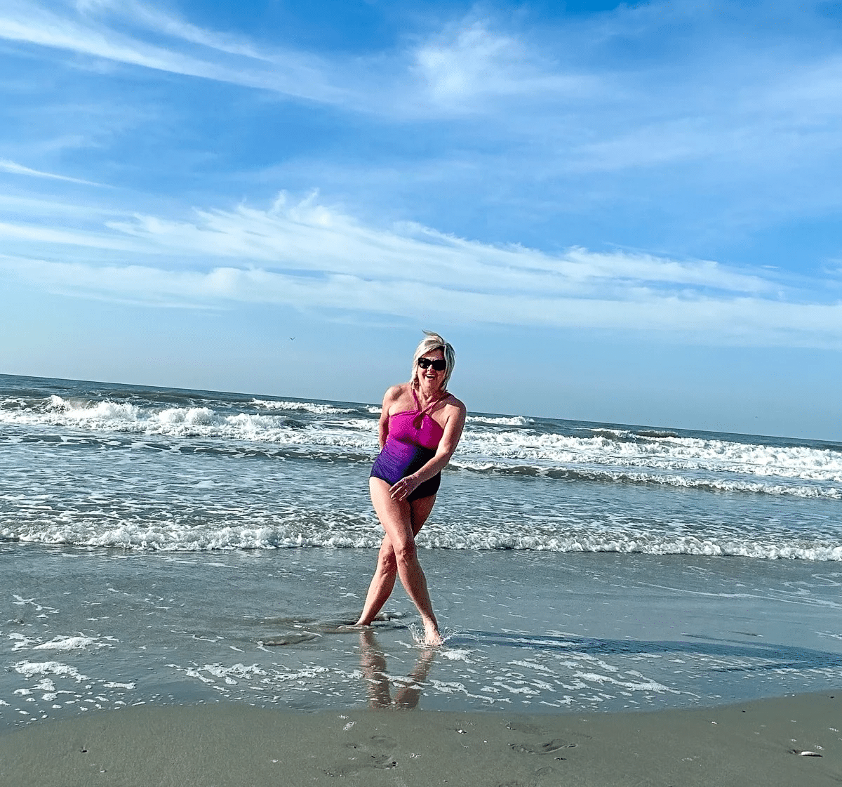 Fashion Blogger Tania Stephens, is wearing a Land's End Swimsuit while playing in the ocean
