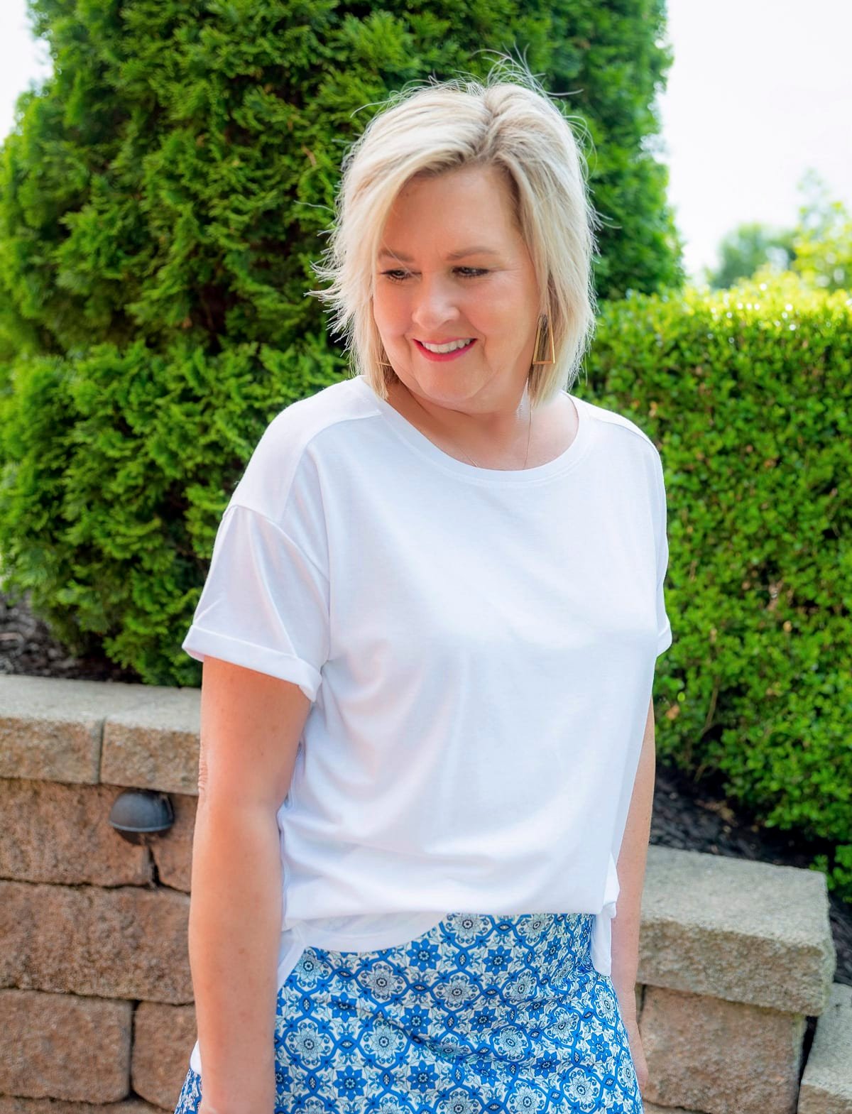 Over 50 Fashion Blogger, Tania Stephens is wearing a white high low top with a skort