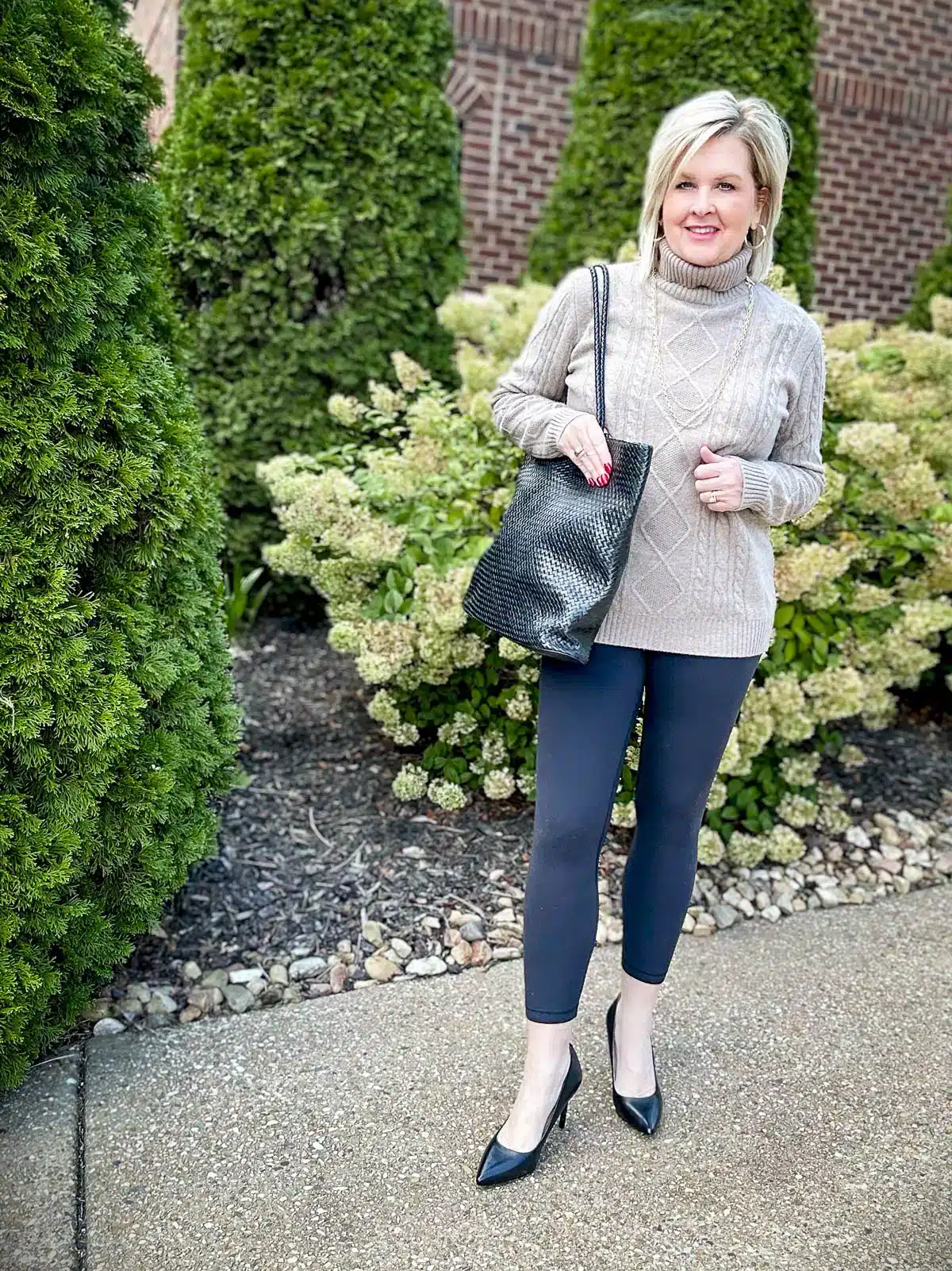 Tania Stephens wearing an turtleneck sweater and black Align Leggings with heels