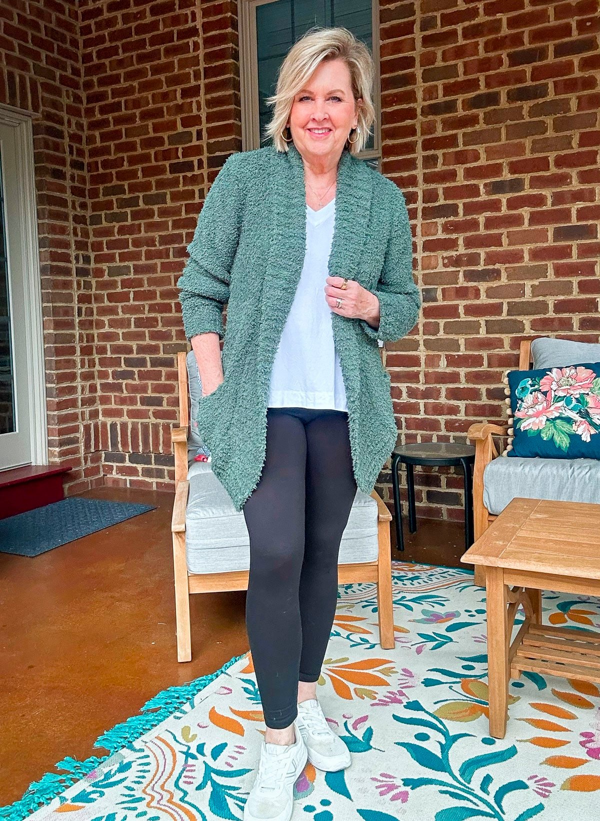 Tania Stephens wearing leggings with a white tunic top and a green cozy cardigan