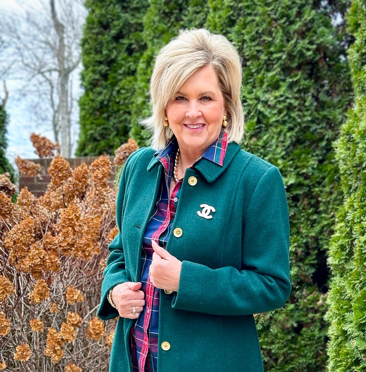 Fashion Blogger Tania Stephens is wearing a green coat with a CC Brooch
