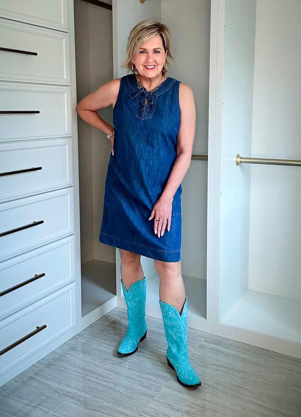 Over 50 Fashion Blogger, Tania Stephens is wearing a denim dress with a pair of brown boots3