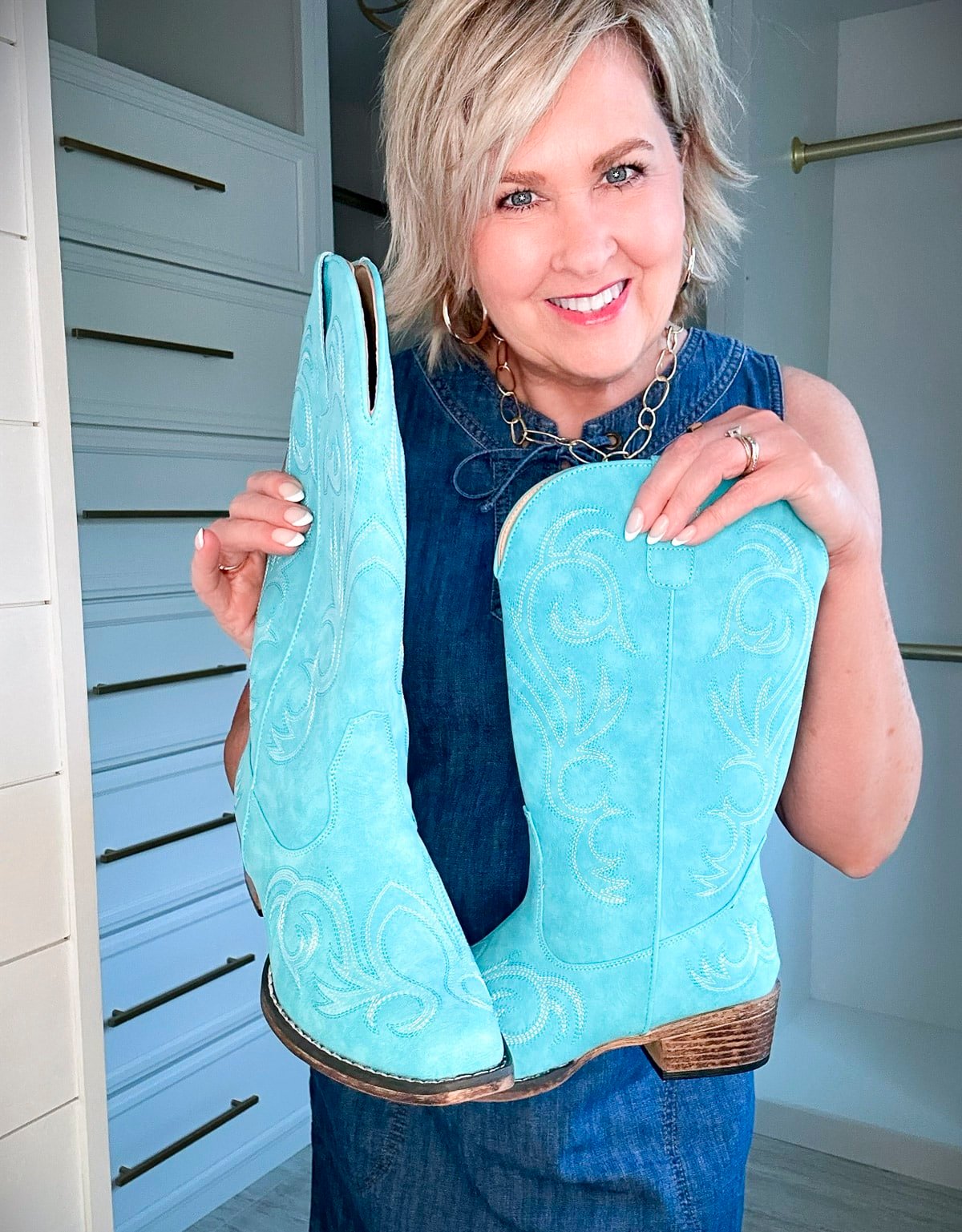 Over 50 Fashion Blogger, Tania Stephens is wearing a denim dress with a pair of brown boots6