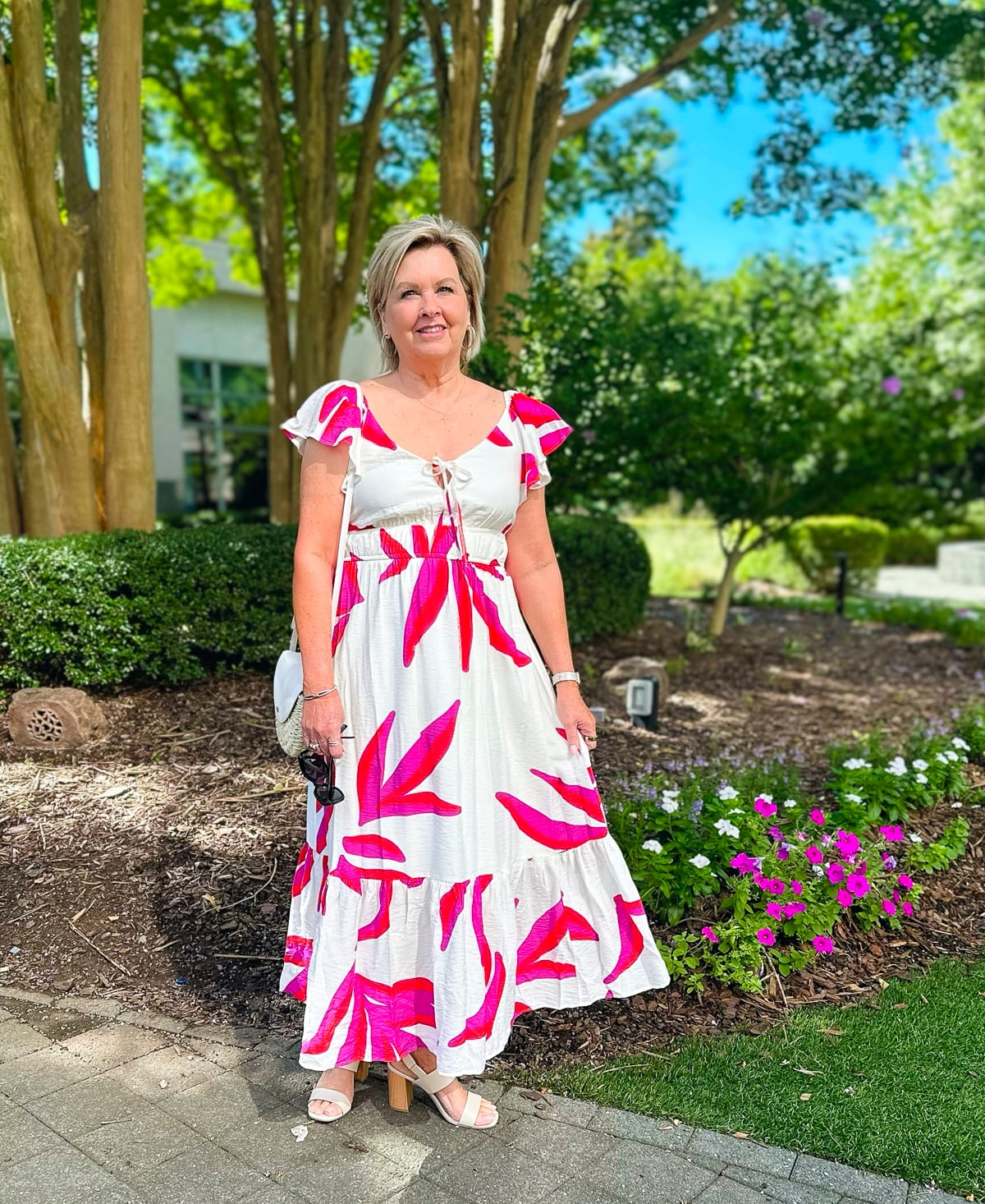 Over 50 fashion blogger, Tania Stephens is wearing a pink tropical sundress from Kohl's
