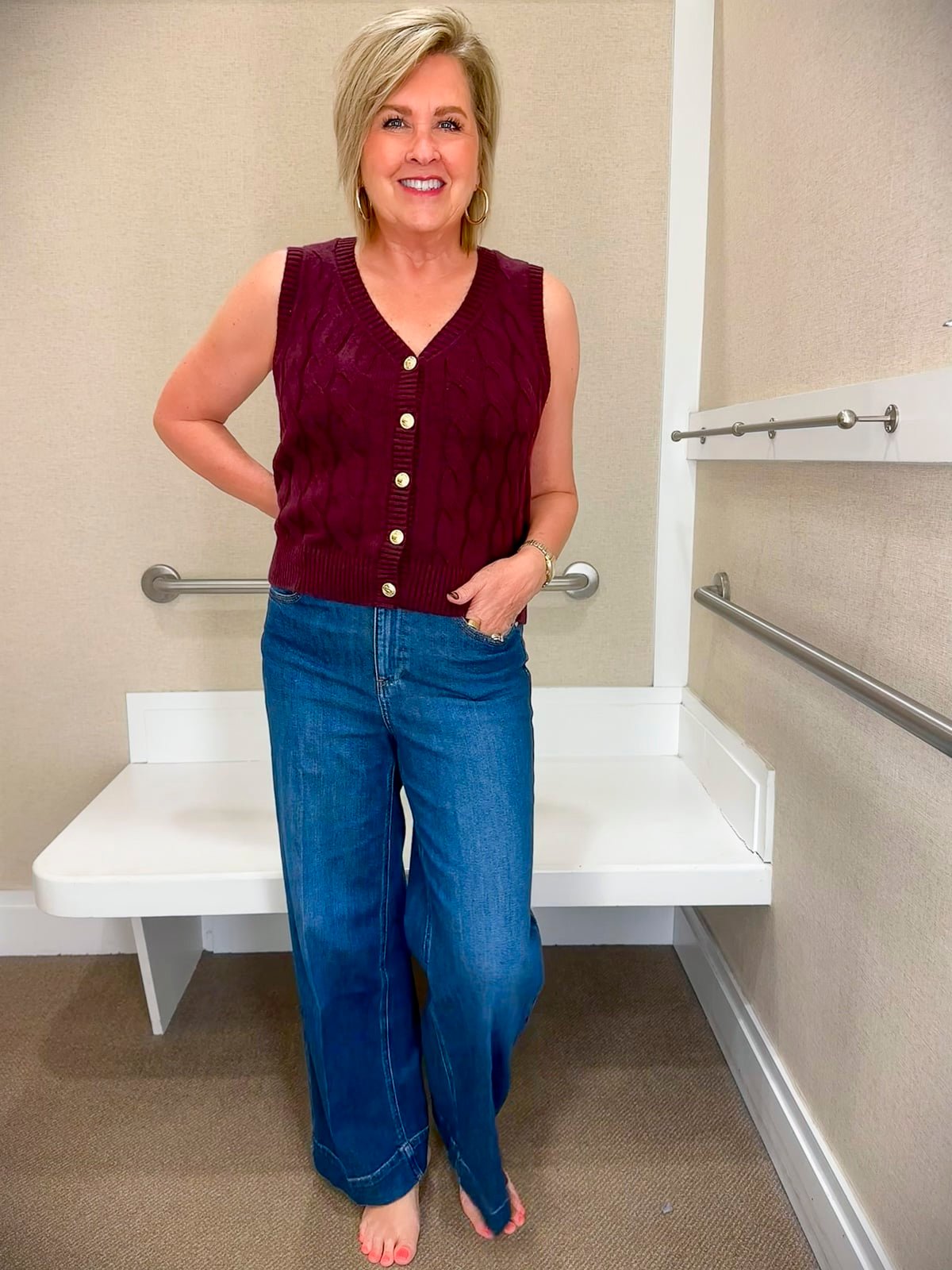 Tania Stephens is styling a burgundy sweater vest and wide leg jeans