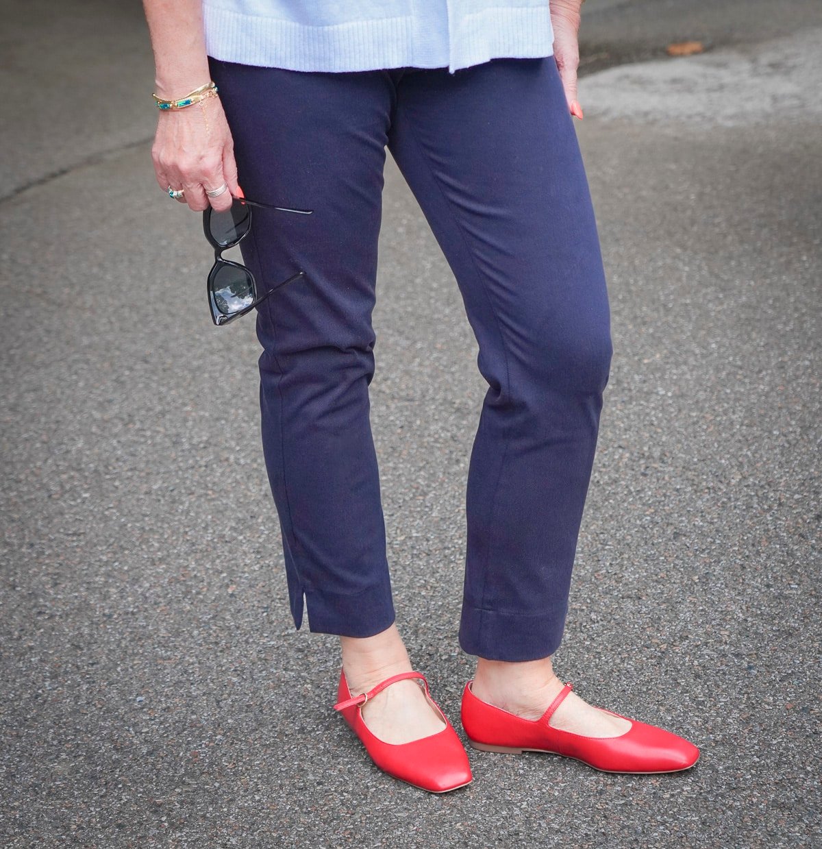 Tania Stephens is wearing a white cardigan and navy pants with fiery red flats1