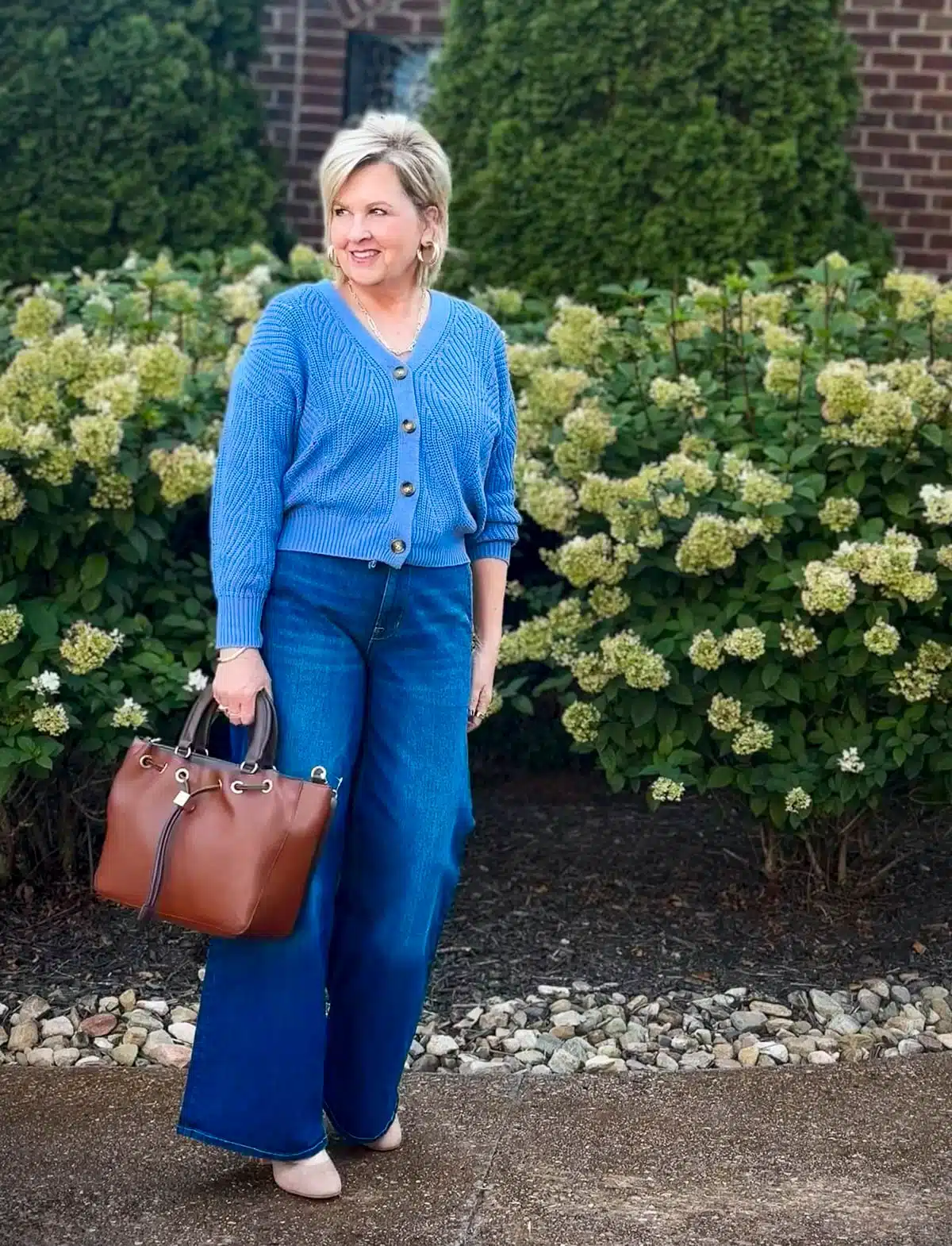 Tania Stephens wearing a blue sweater and wide leg jeans