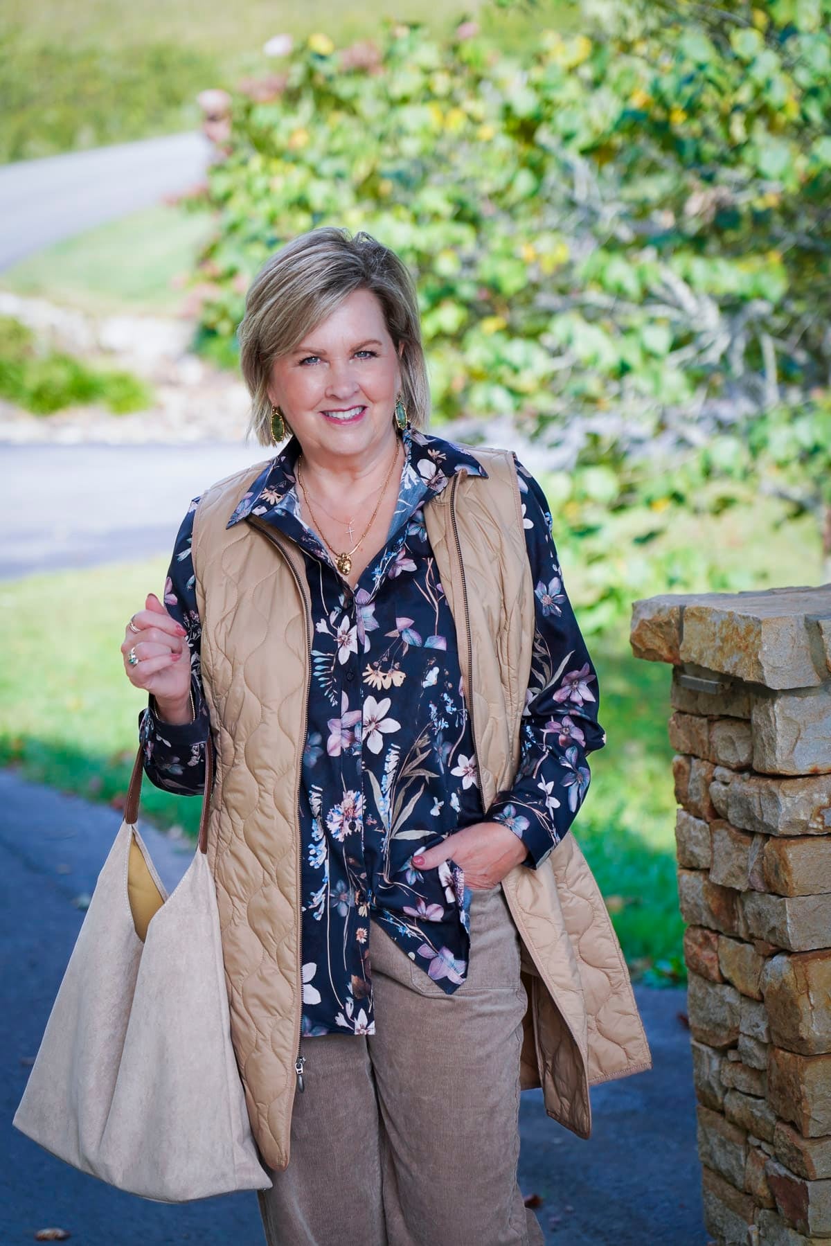 Tania Stephens is wearing a floral button up shirt, corduroy pants, and a long vest during a Coldwater Creek Try On Haul for fall