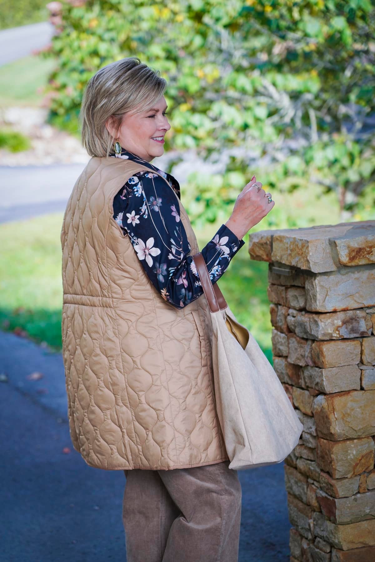 Tania Stephens is showing the back of a floral button up shirt and a long vest