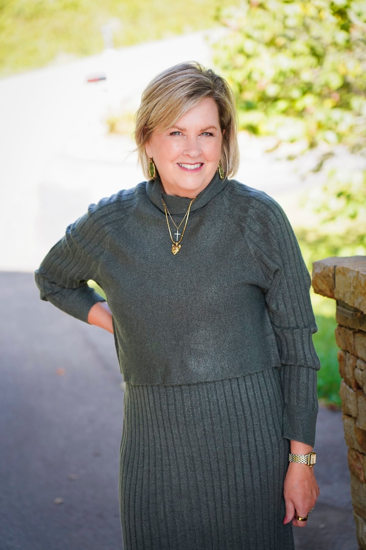 Tania Stephens is wearing a green sweater dress with a cropped top for fall from Coldwater Creek