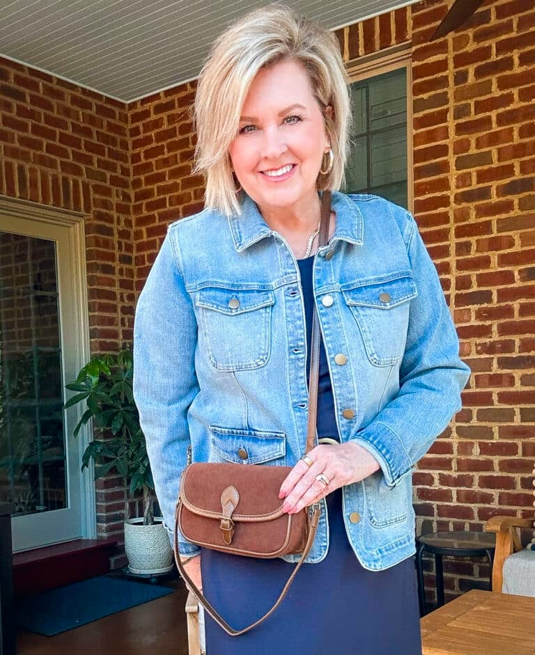 Tania Stephens is wearing a denim jacket, a navy maxi dress and a brown crossbody