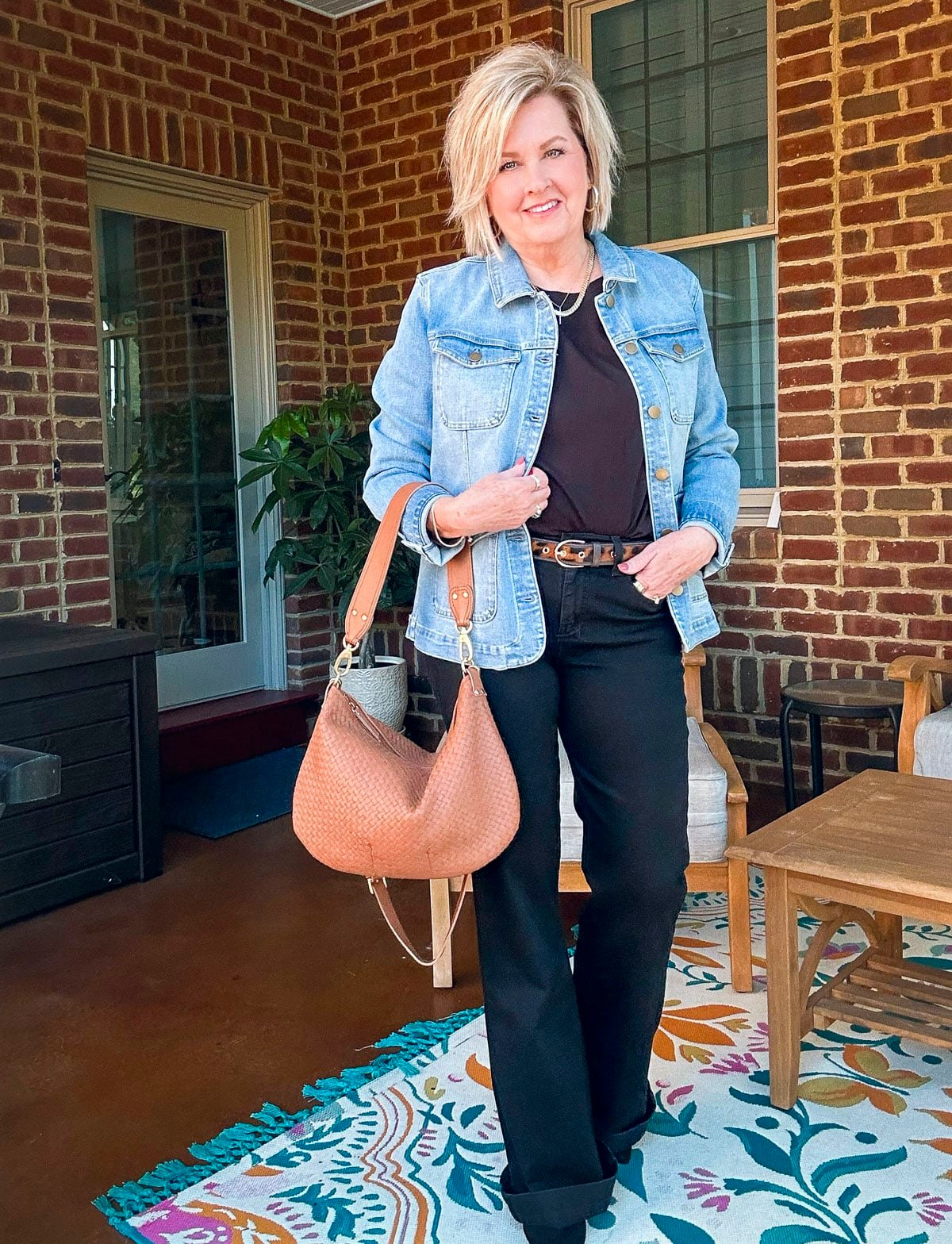 Tania Stephens is wearing a denim jacket a black tee and jeans