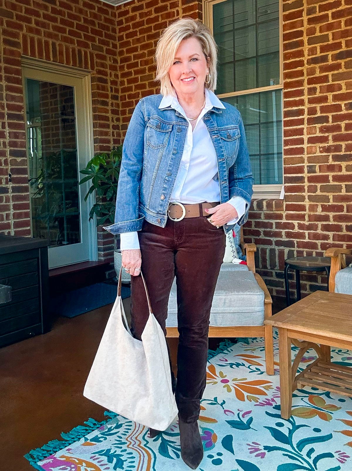 Tania Stephens is wearing a denim jacket for fall with chocolate brown corduroy pants