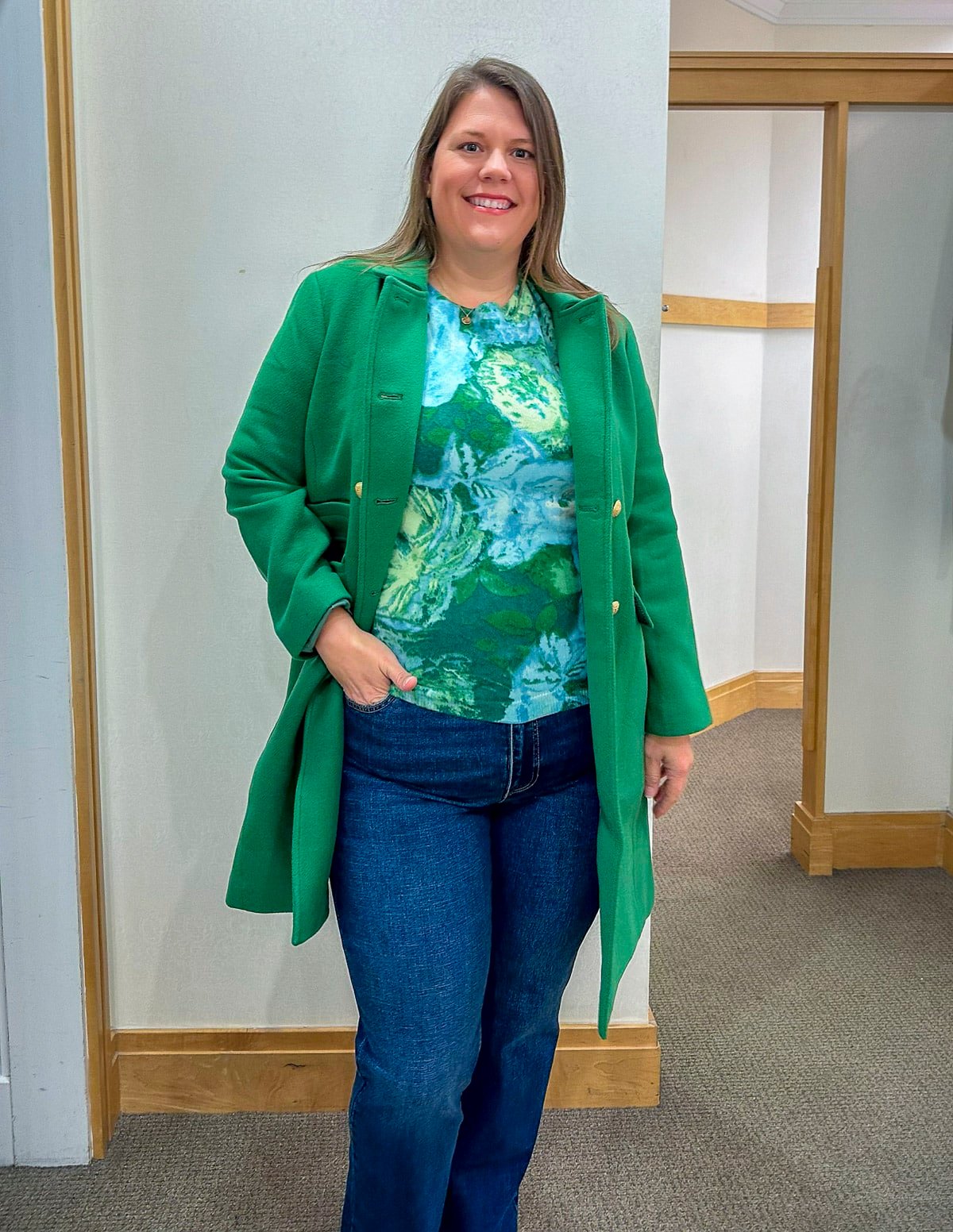 Megan is trying on a Talbots green coat, a cashmere sweater and bootcut jeans