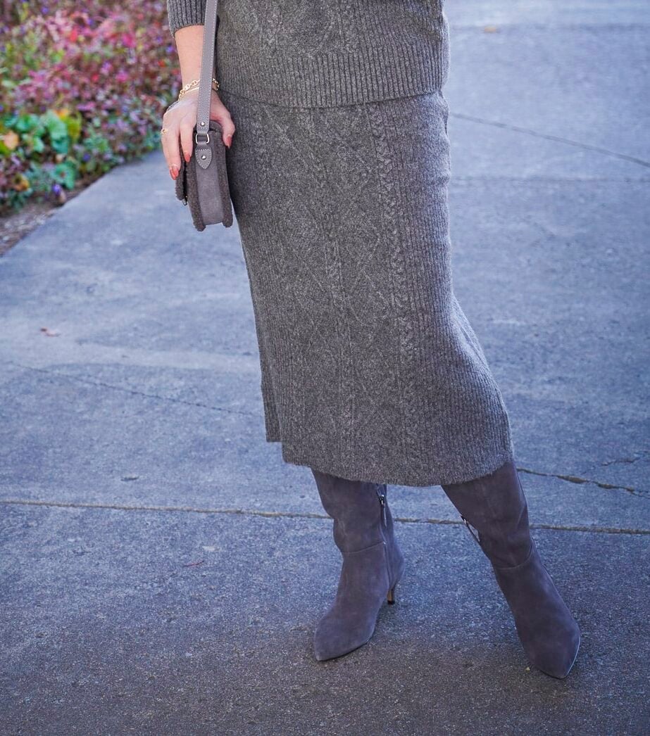 Tania Stephens is wearing a gray cable knit sweater skirt and knee boots