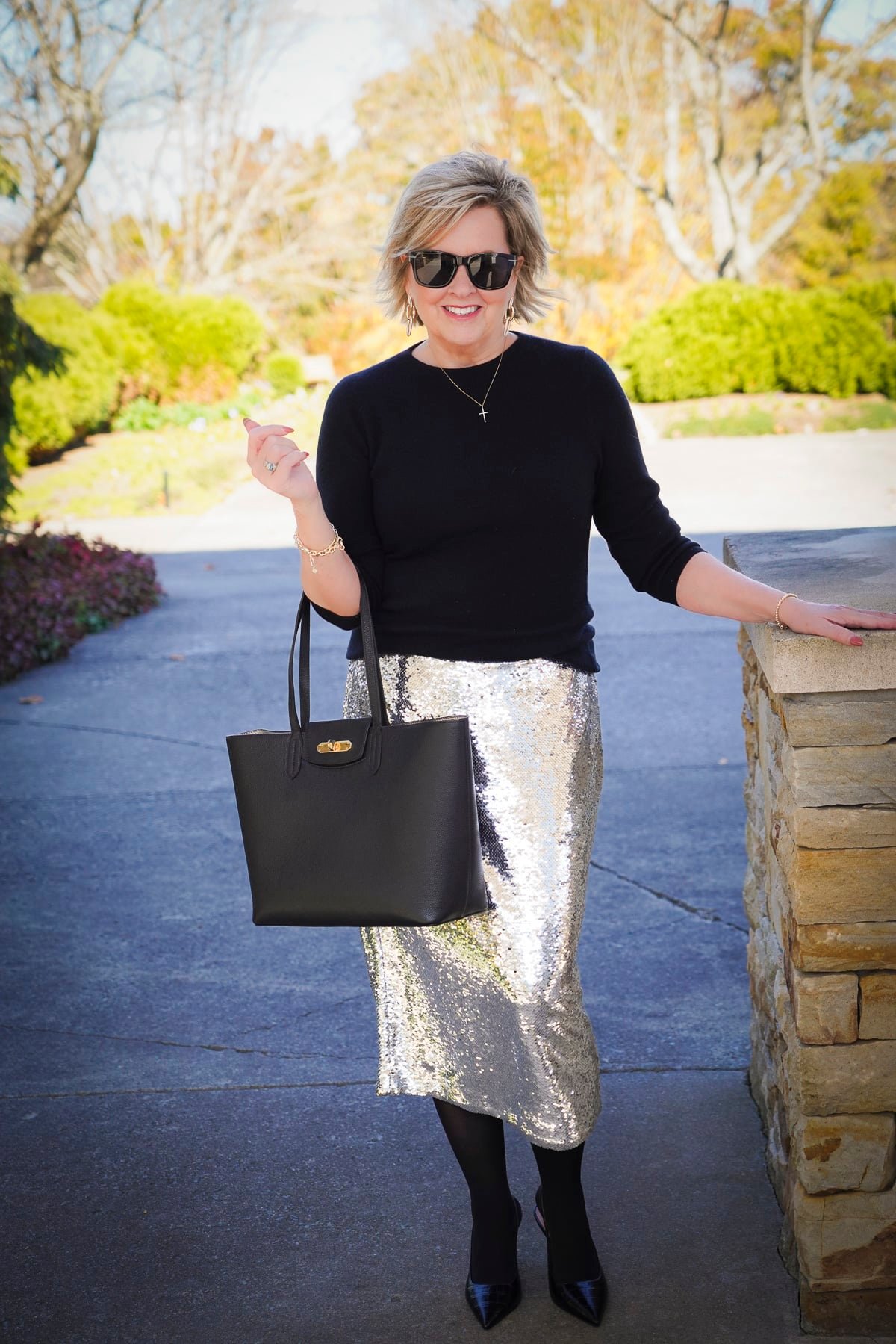 Tania Stephens is wearing a black cashmere sweater and a midi sequin skirt