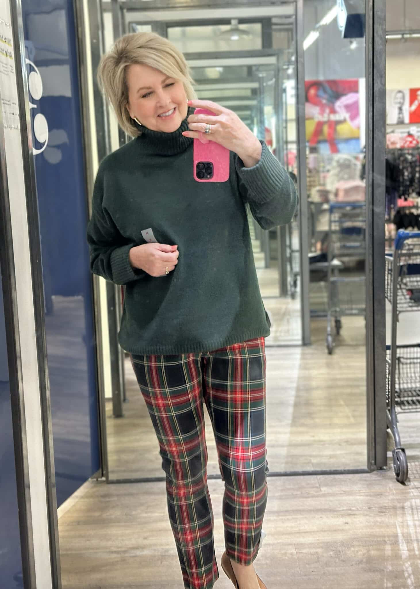 Tania is wearing a green sweater and plaid pants