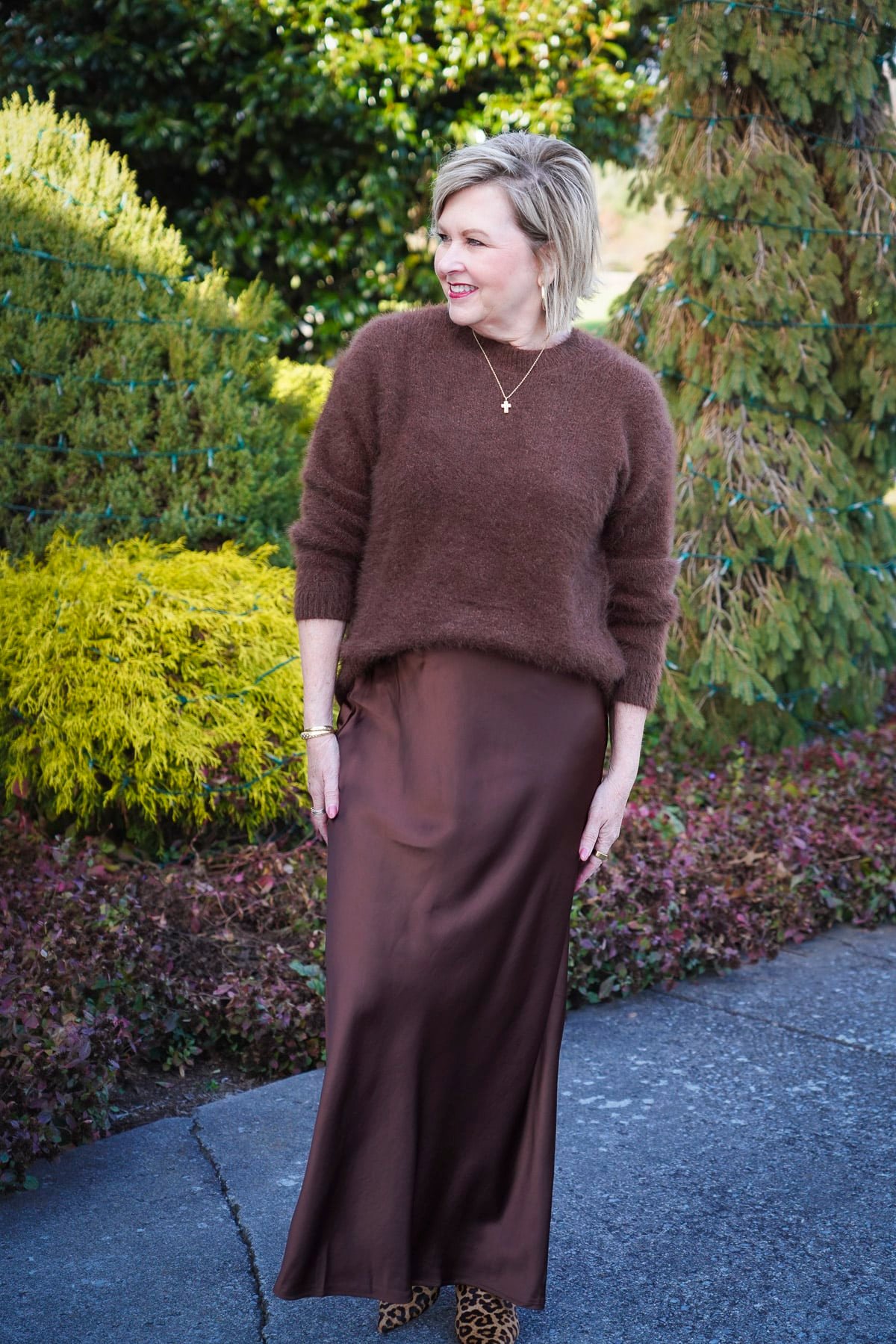 Tania Stephens is wearing a brown fuzzy sweater and satin slip