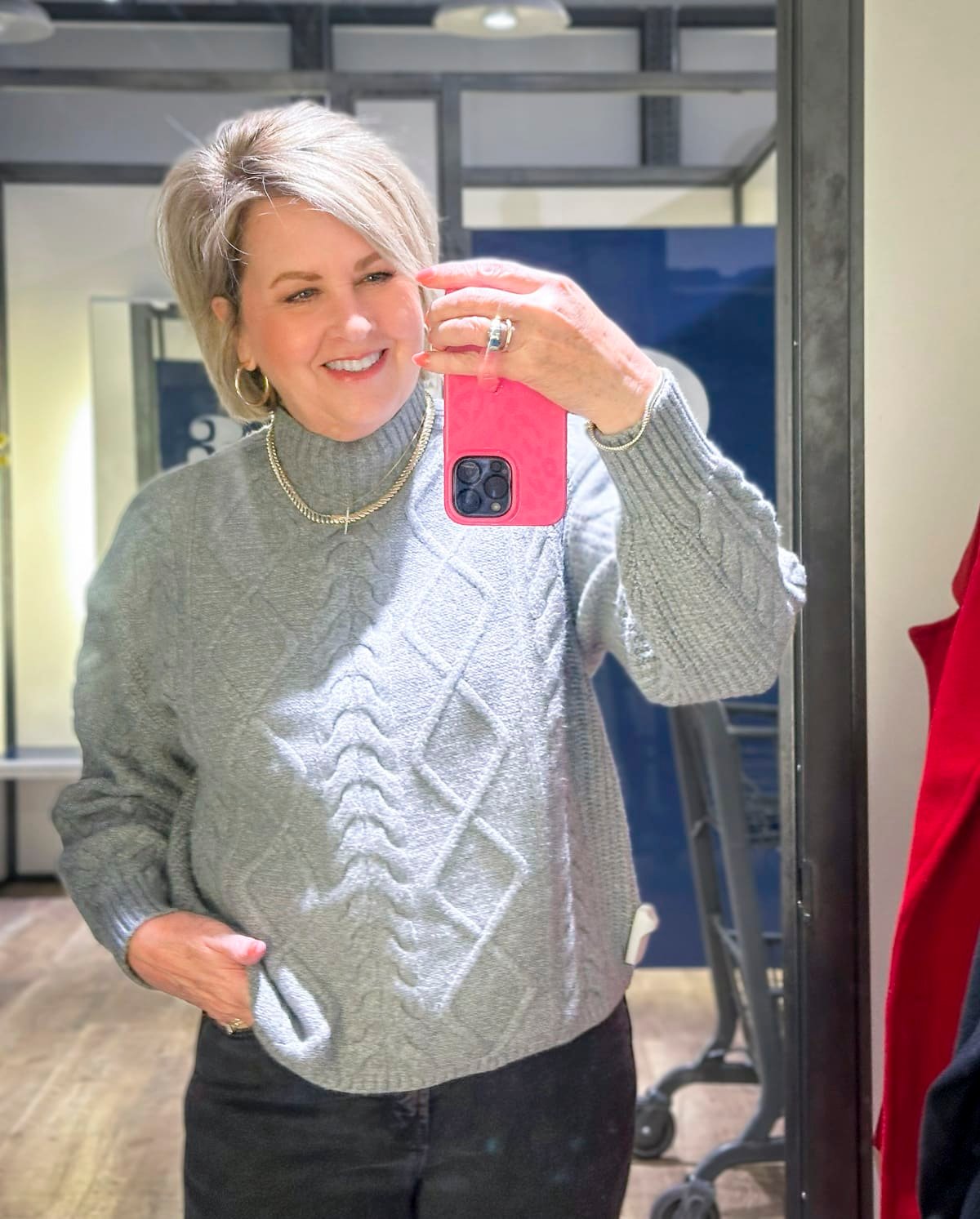 Tania is wearing a gray cable knit sweater