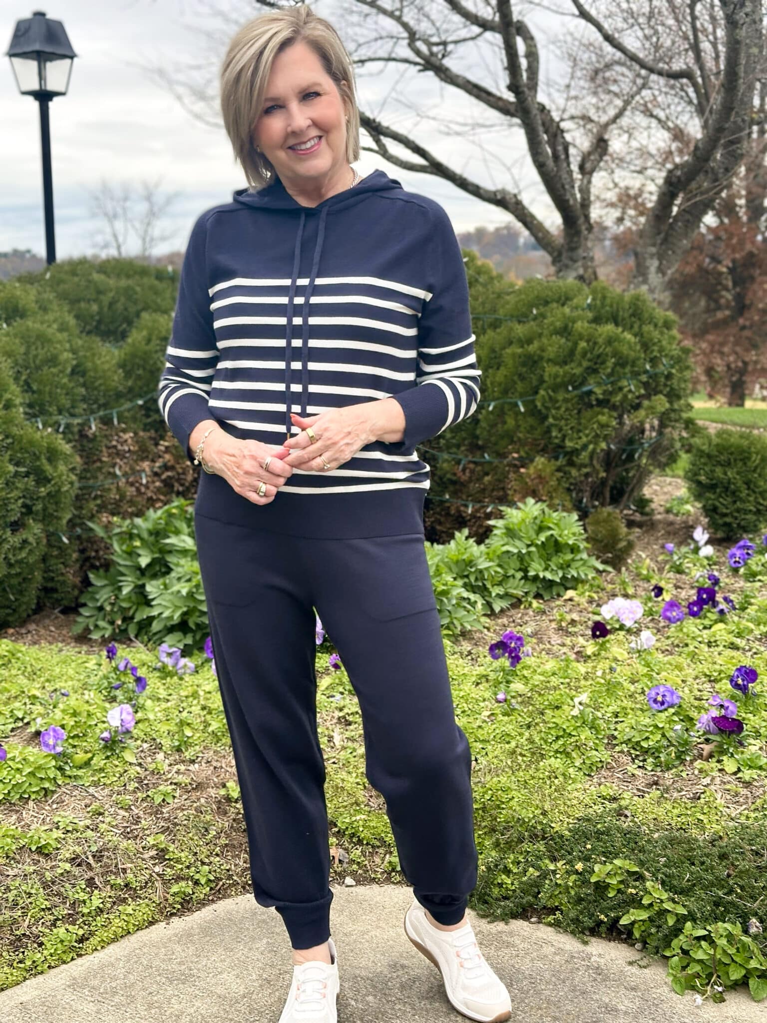 Tania Stephens is wearing a navy and white hoodie sweater and matching navy jogger pants