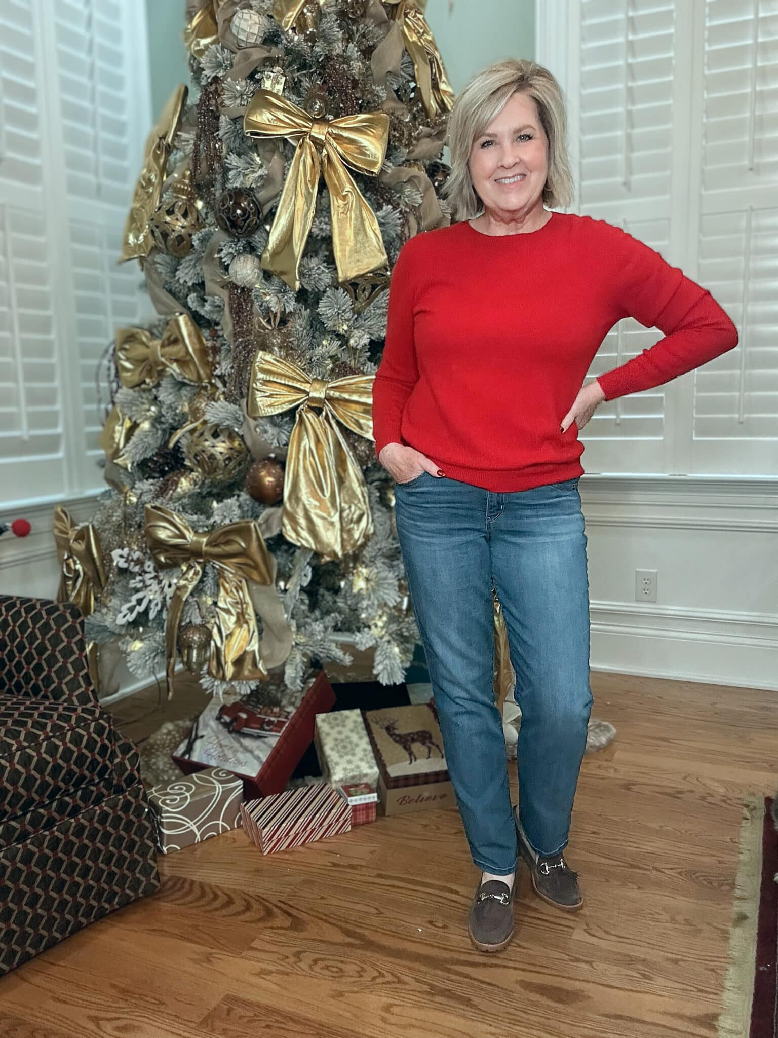 Tania Stephens is wearing a soft, red sweater with straight-leg jeans