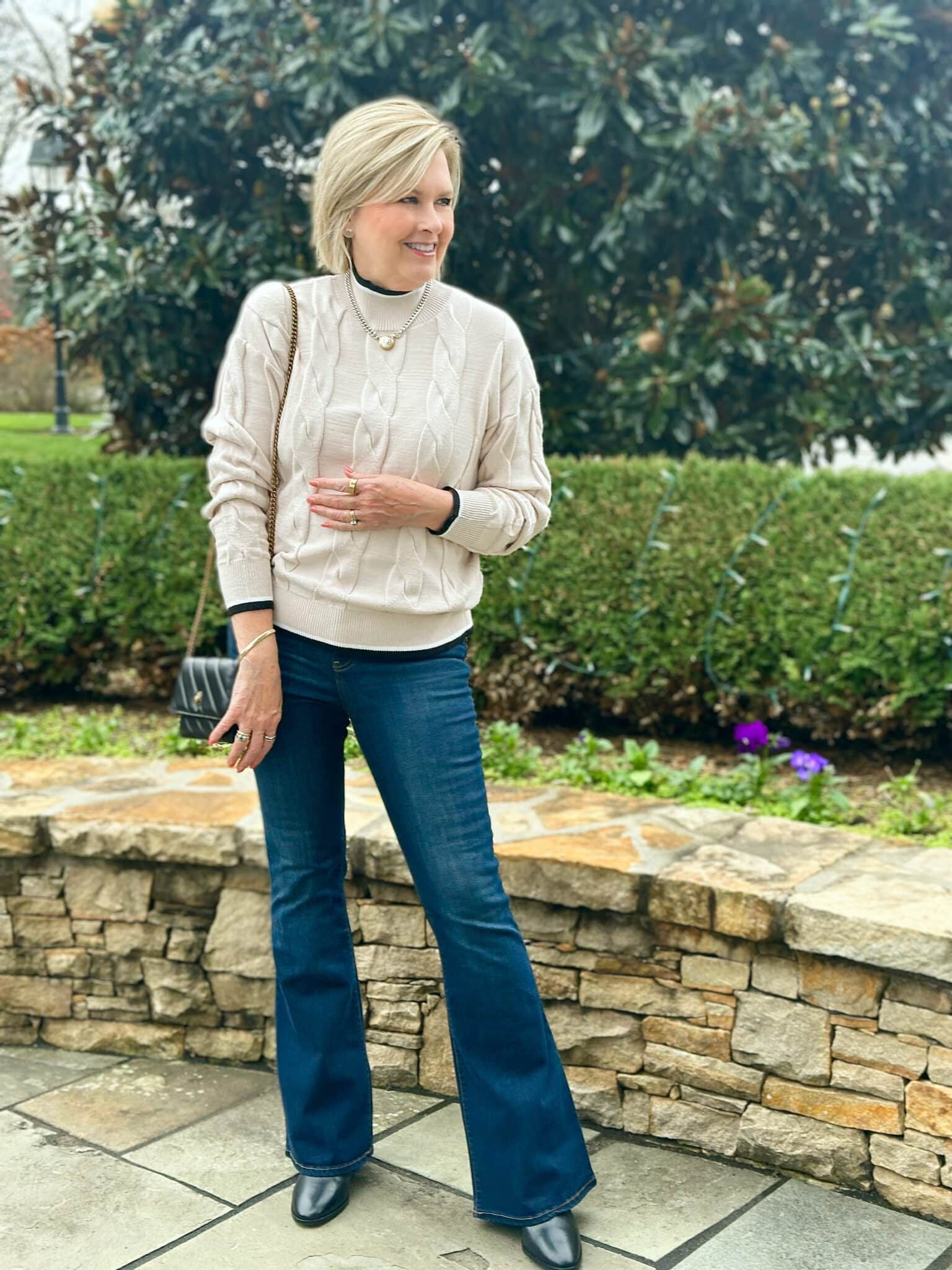 Tania Stephens is wearing an ivory Amazon cable knit sweater with flare jeans