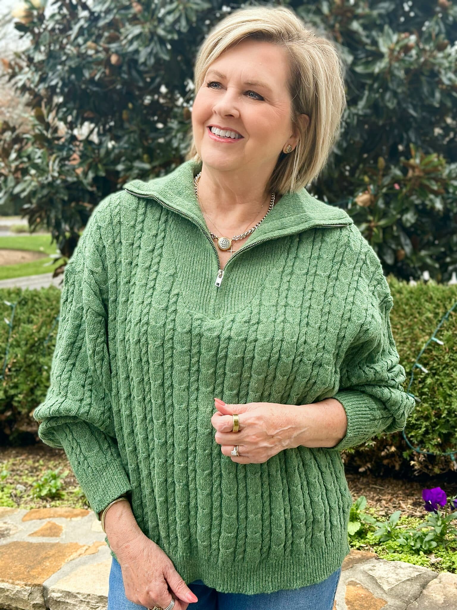 Tania Stephens is wearing a green quarter-zip sweater 