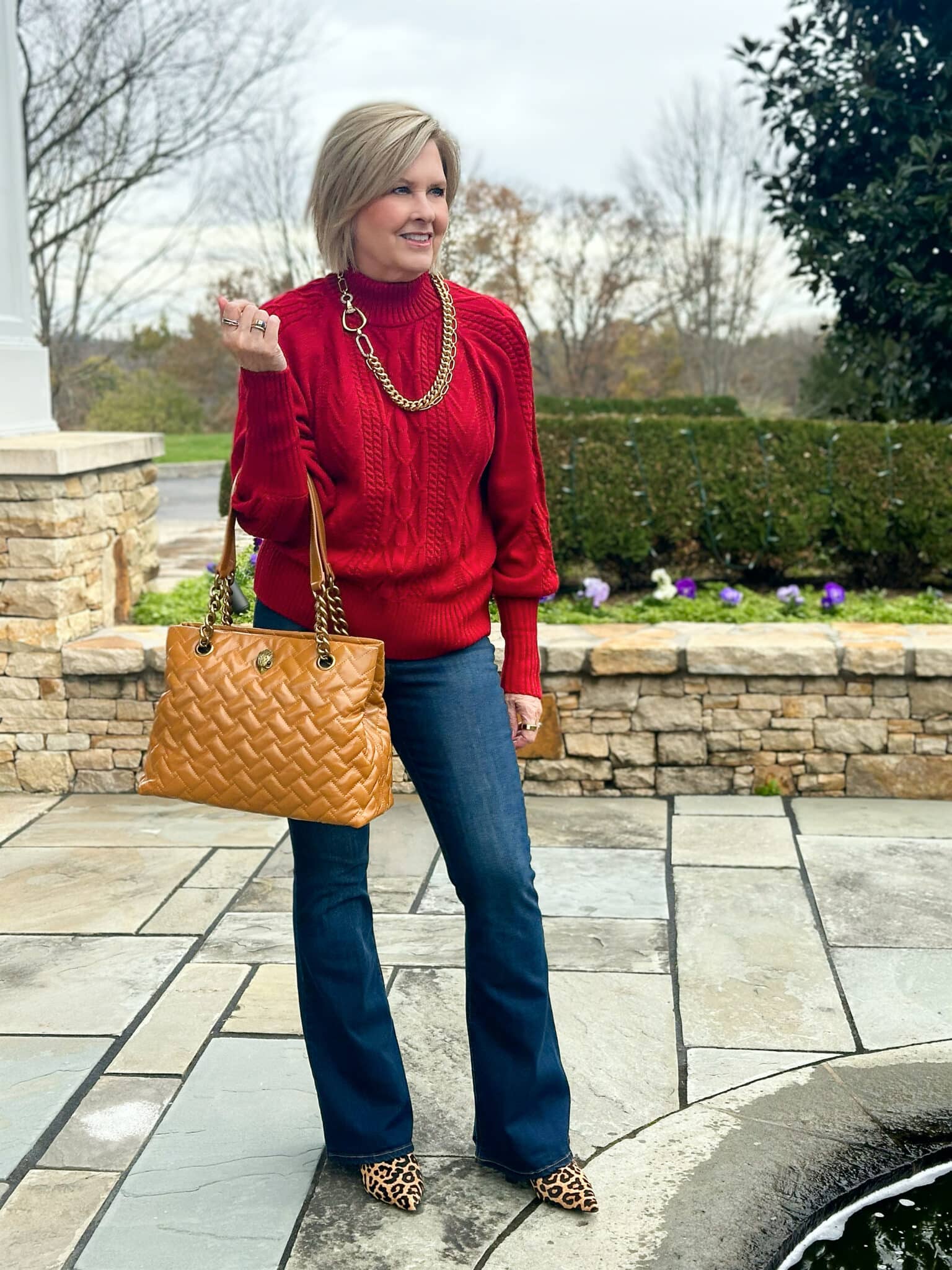 Tania Stephens is wearing a red Amazon turtleneck sweater with flare jeans