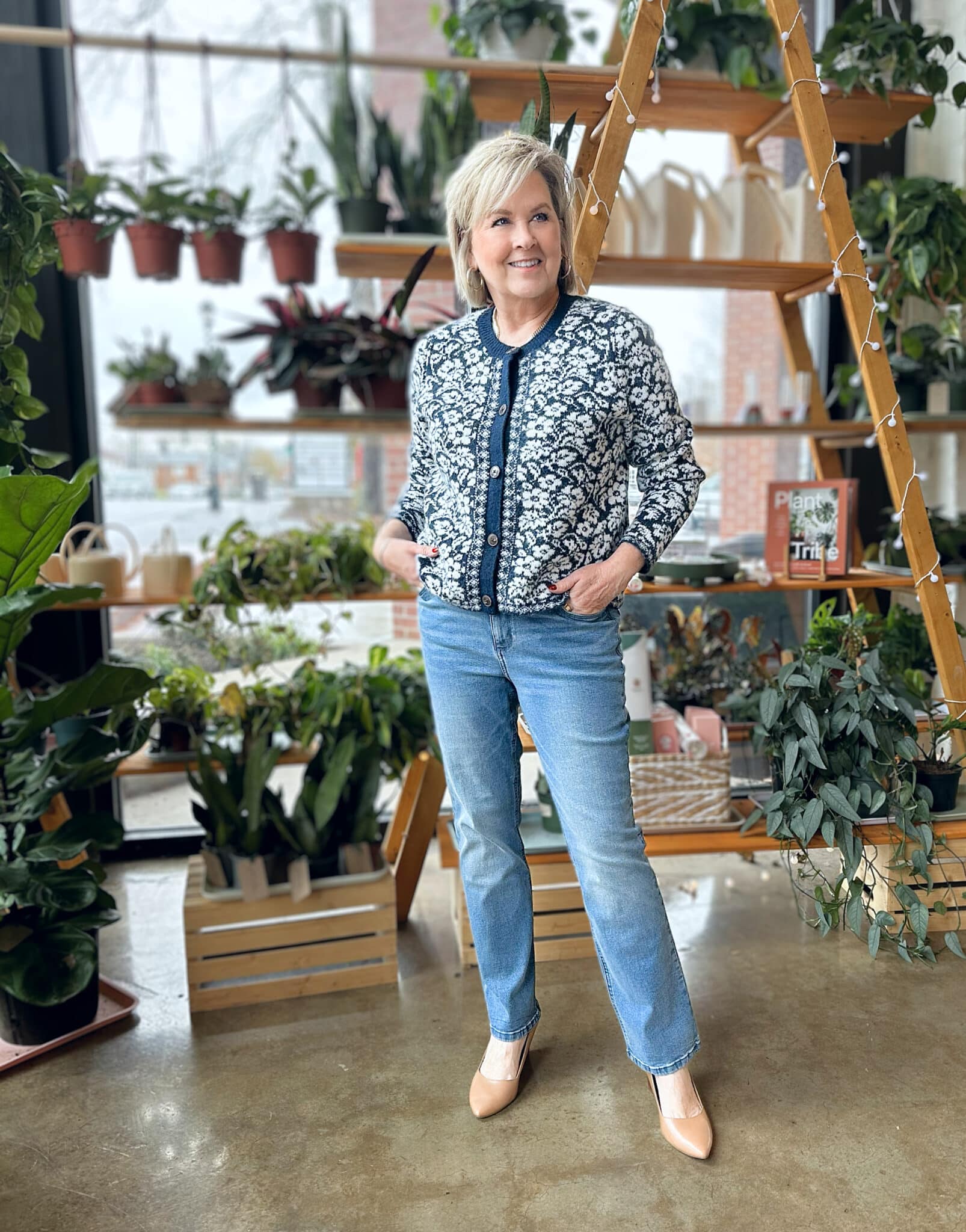 Tania Stephens is wearing a floral navy and white Draper James cardigan sweater and straight leg jeans from Kohl's