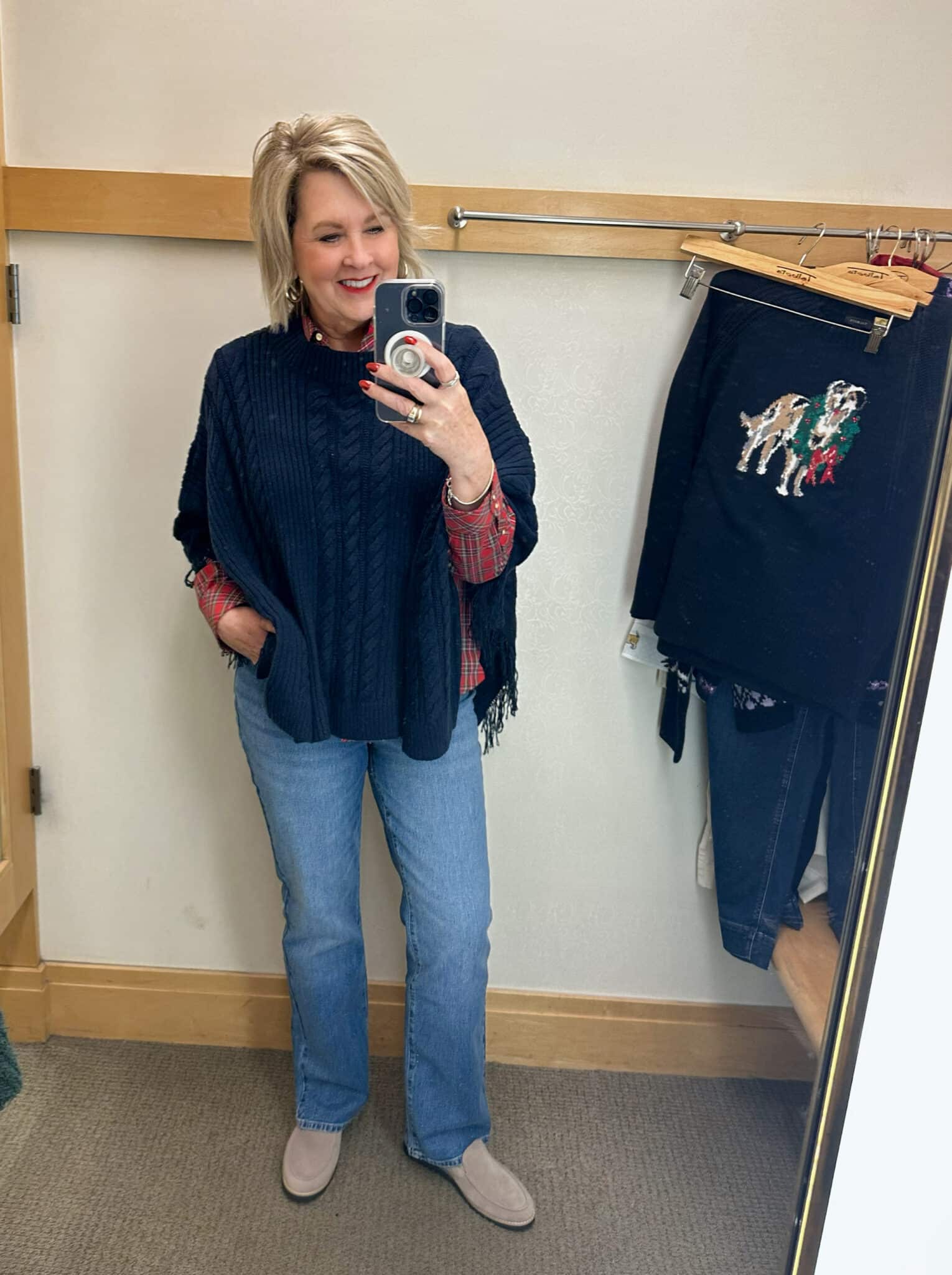 Tania Stephens wearing a navy cable knit poncho and bootcut jeans