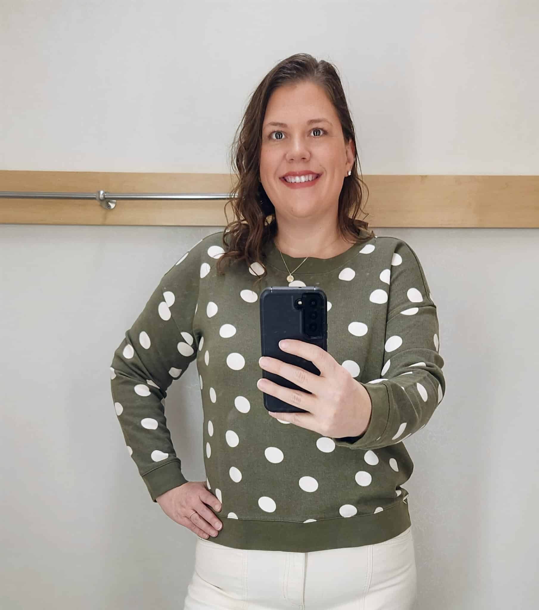 Megan is wearing a green sweater with ivory dots