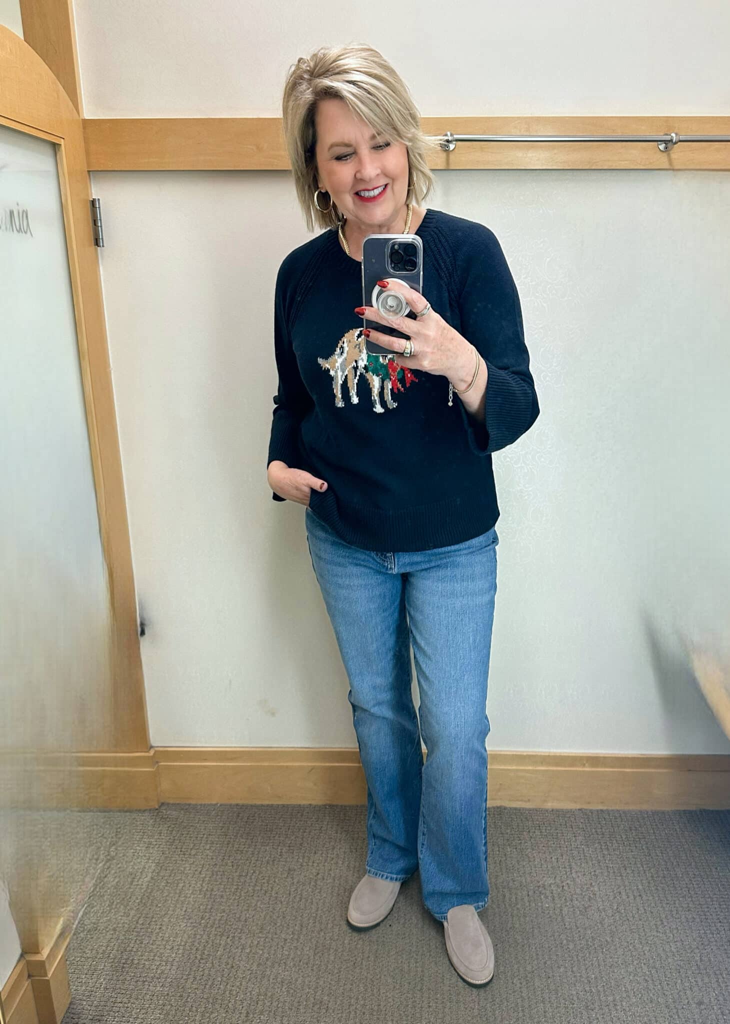 Tania Stephens is wearing a navy sweater with a dog, and jeans