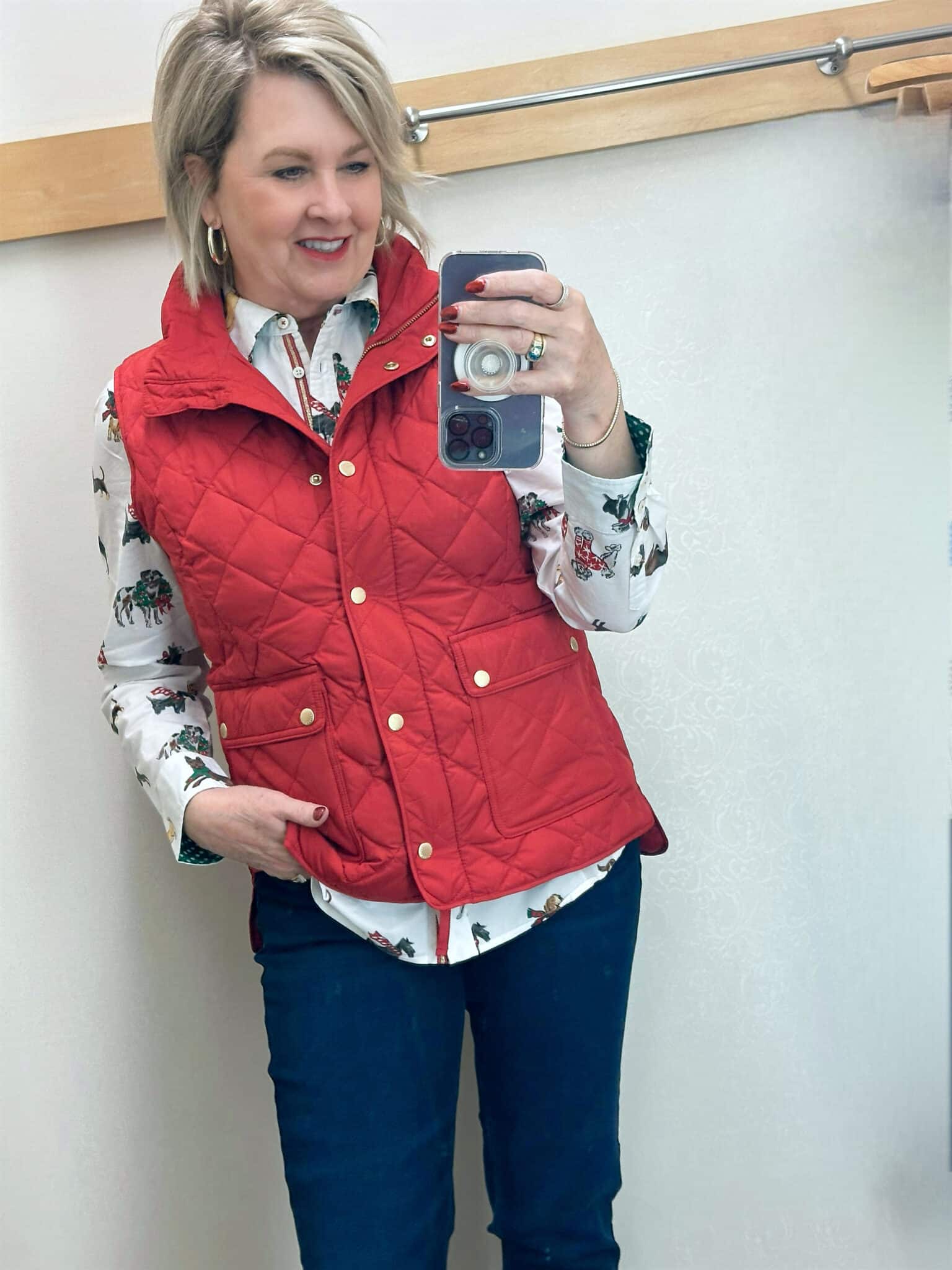 Tania Stephens is wearing a button up shirt with a red puffer vest