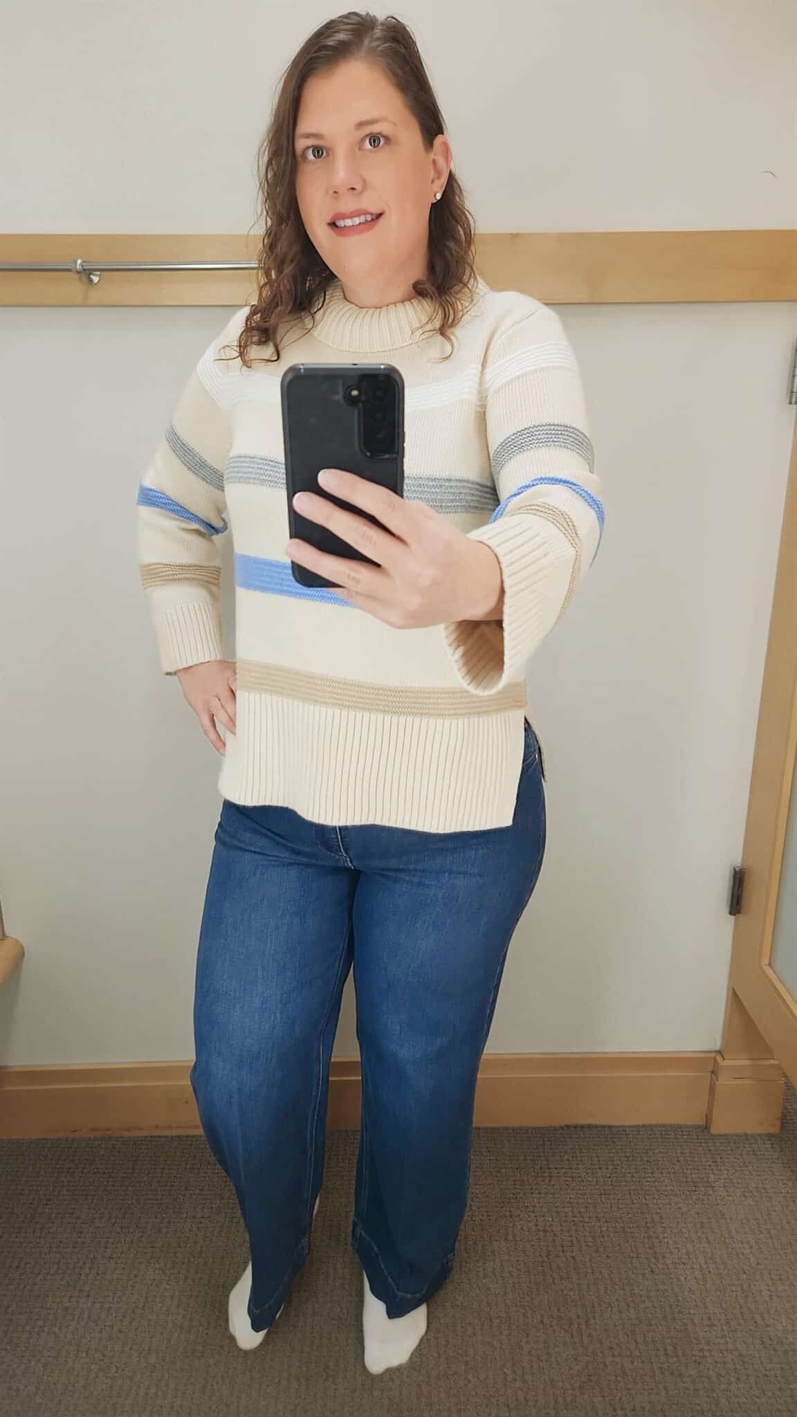 Megan is wearing a striped sweater and jeans