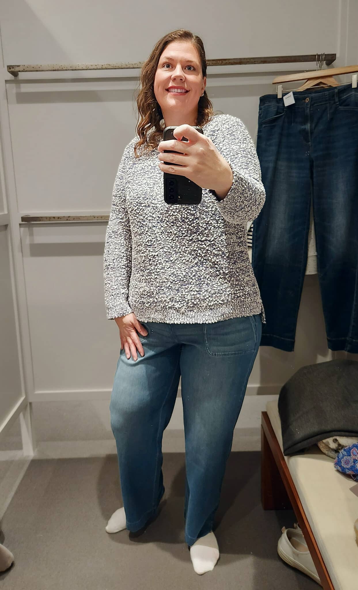 Megan is wearing a gray textured sweater and jeans from J.Jill