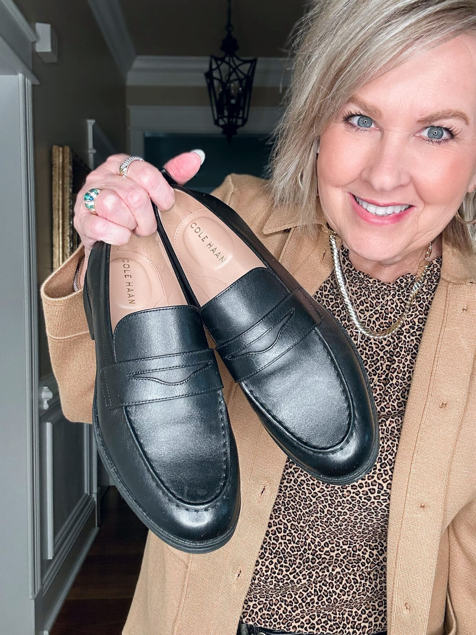 Tania Stephens is wearing a camel knit blazer and Cole Hann Loafers