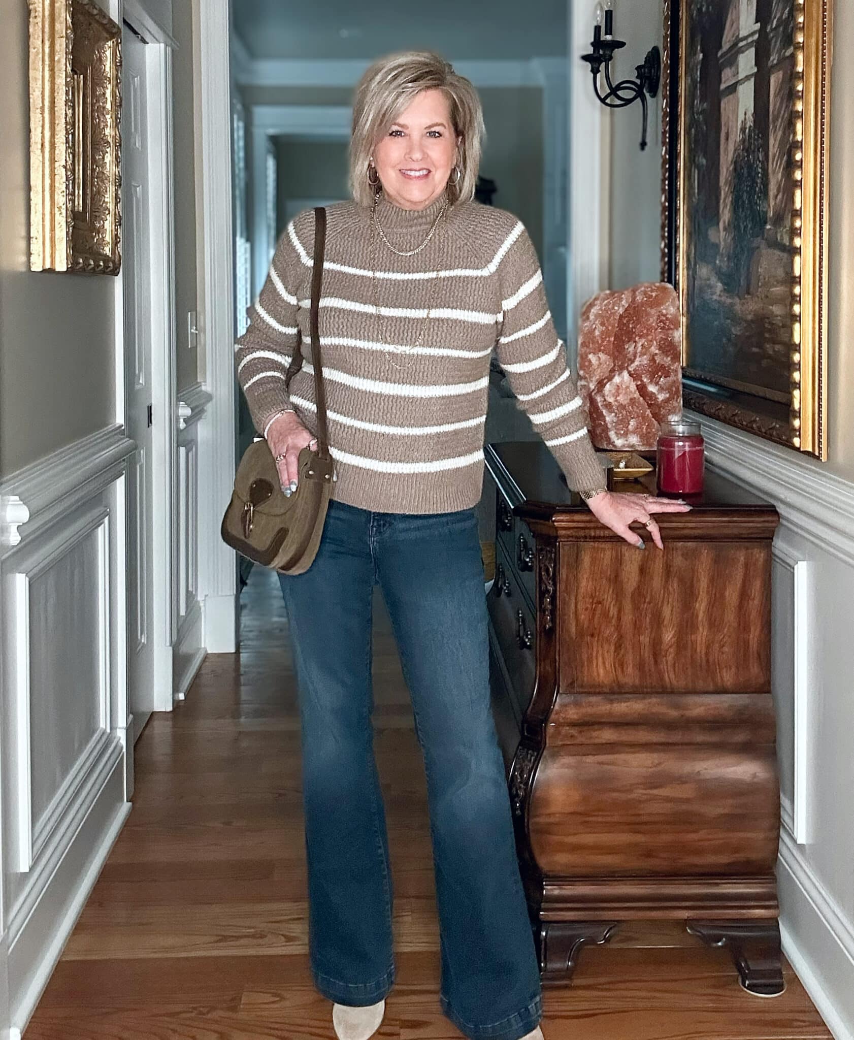 Tania Stephens is wearing a striped mocha colored sweater and flare jeans