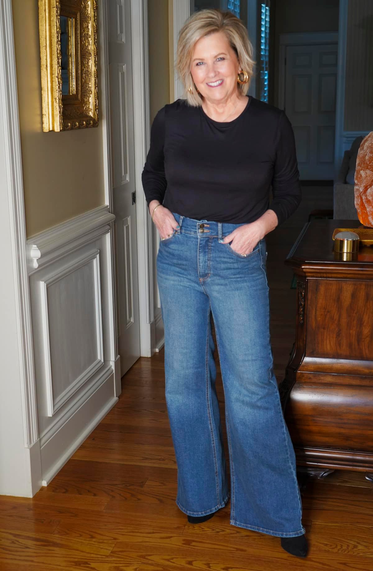 Tania Stephens, an over 50 fashion blogger, is styling an affordable pair of wide leg jeans and a black tee from Walmart