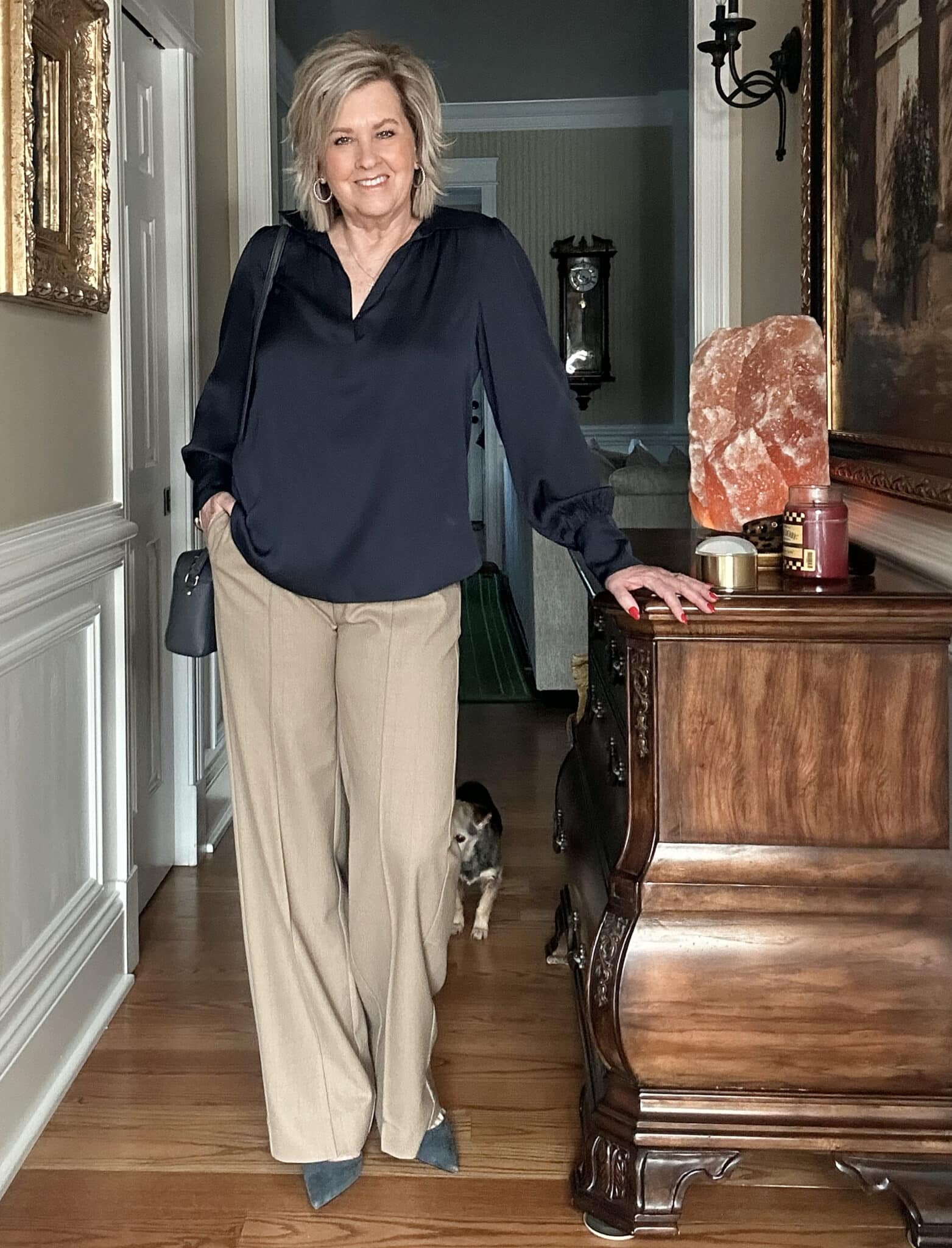 Over 50 fashion blogger, Tania Stephens is wearing a navy satin top and checked tan pants