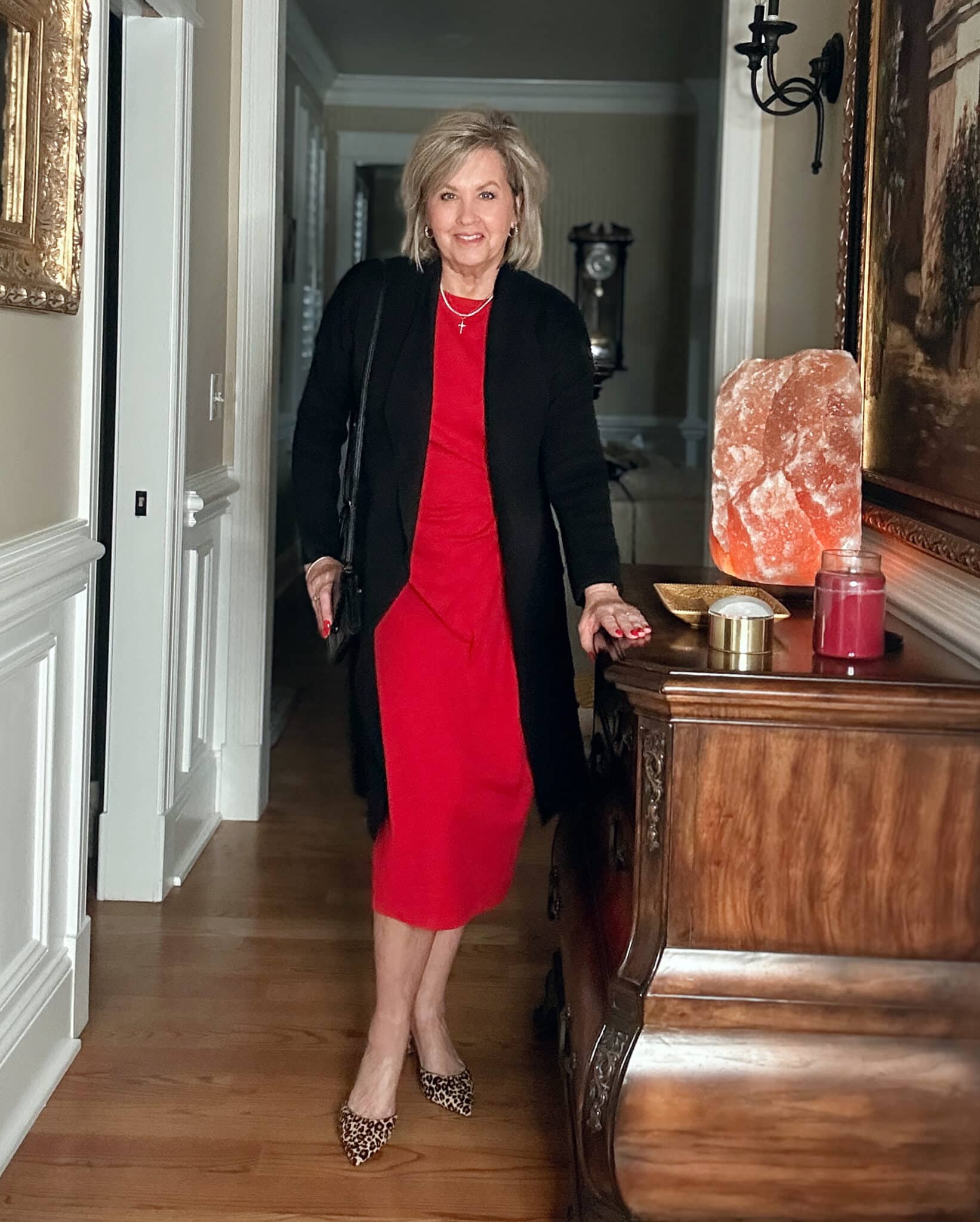 Tania Stephens wearing affordable and budget friendly clothing - a black cardigan and a red tie waist dress