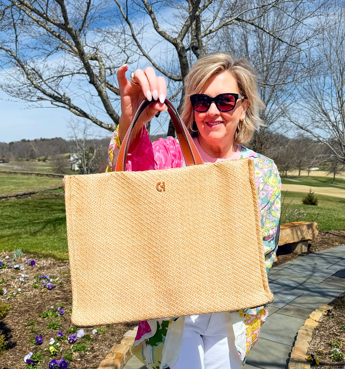 Tania Stephens wearing 2025 Spring styles of a colorful jacket and a straw handbag from Nordstrom Rack