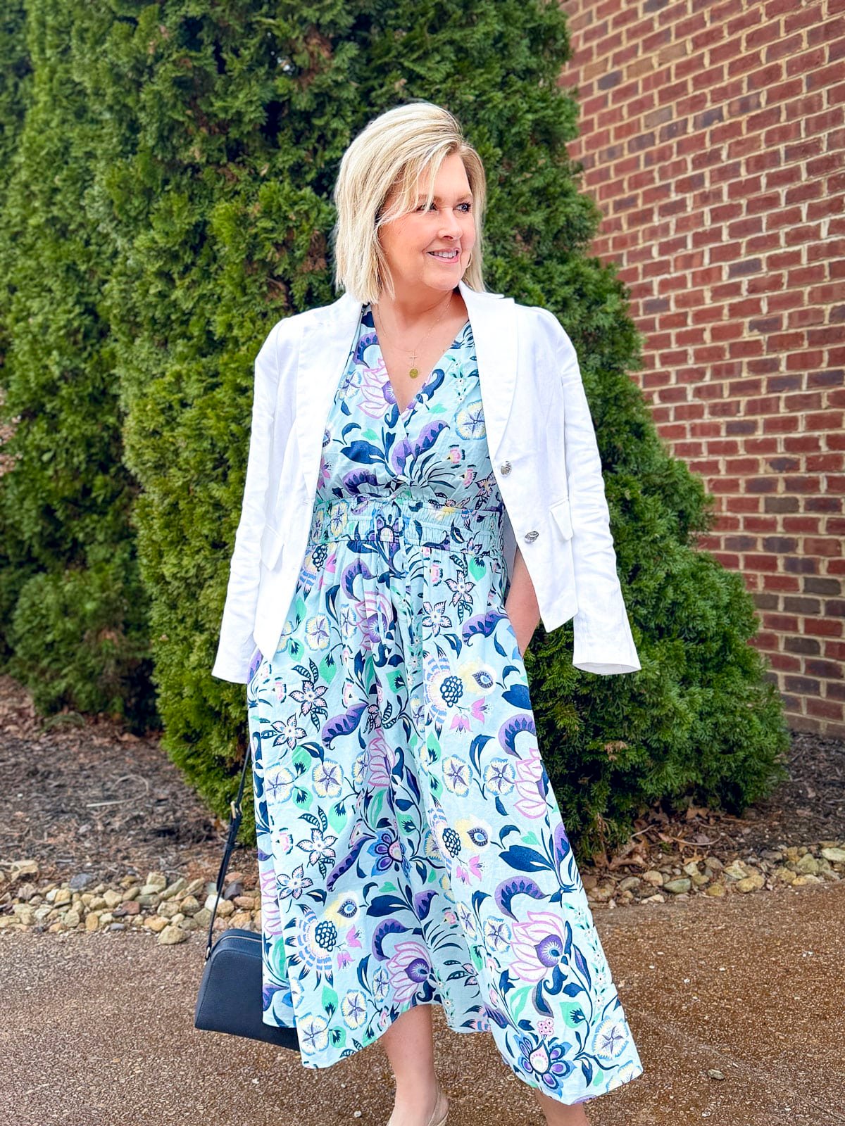 Tania Stephens wearing a Spring outfit of a cropped white linen jacket and a colorful midi dress from Talbots