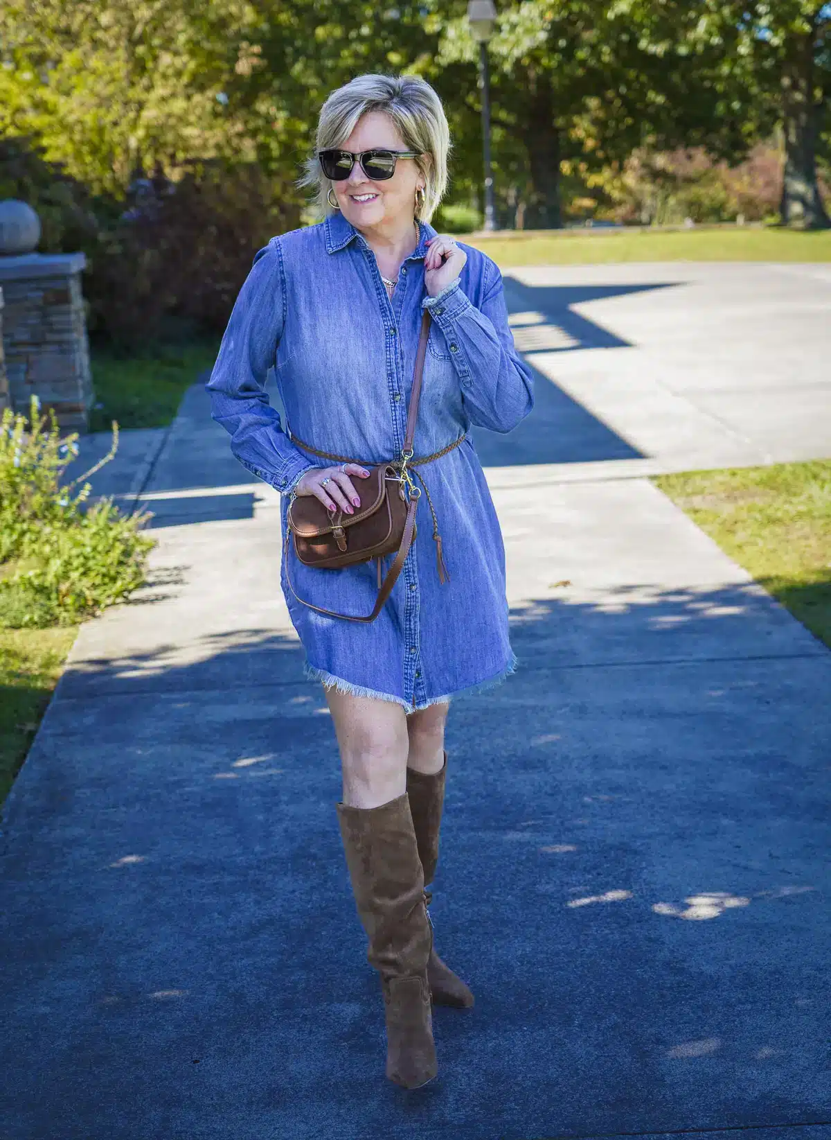 a woman wearing a denim dress and boots