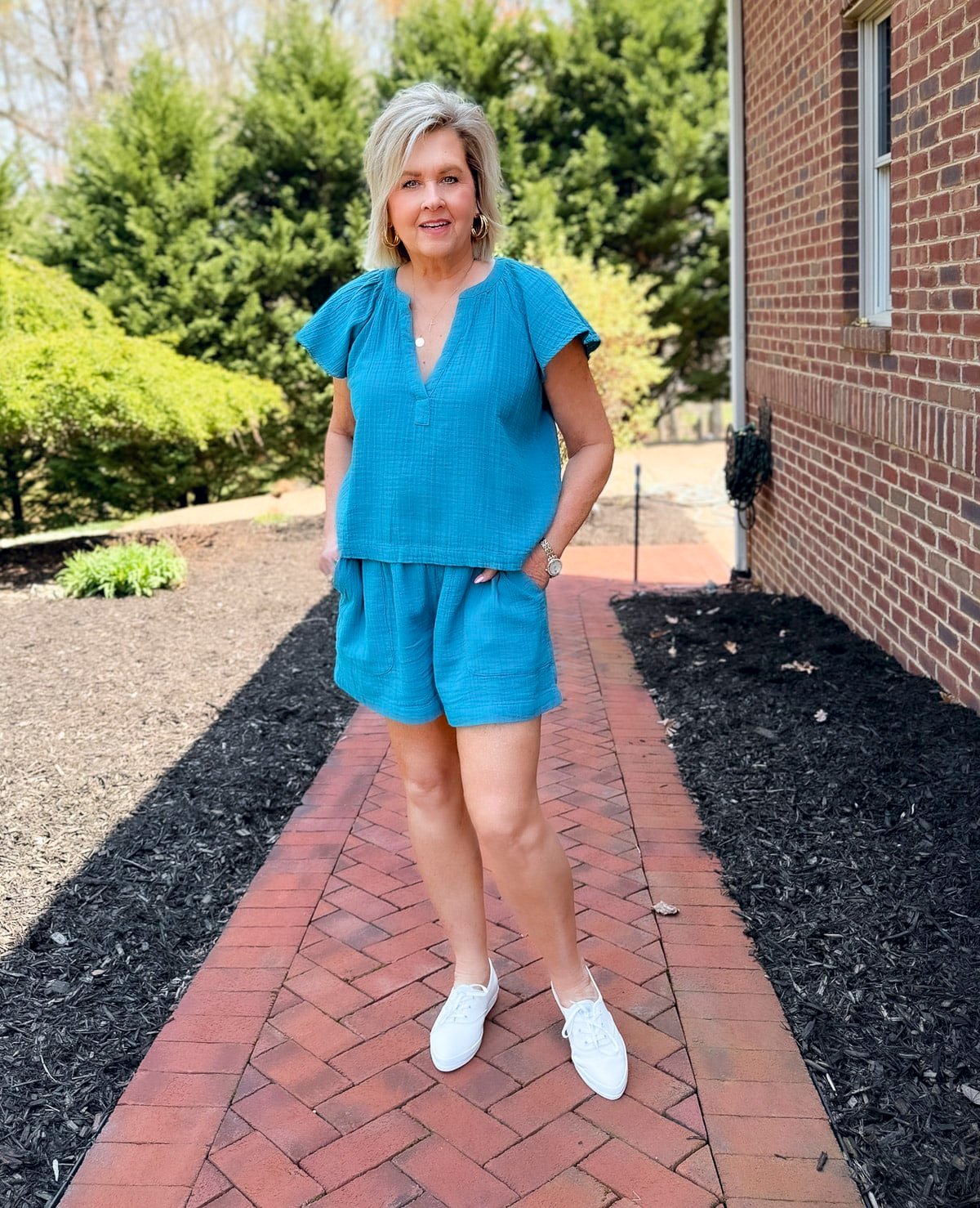 woman wearing a blue shorts outfit and wearing Keds Champion Point Low Leather Lace Up
