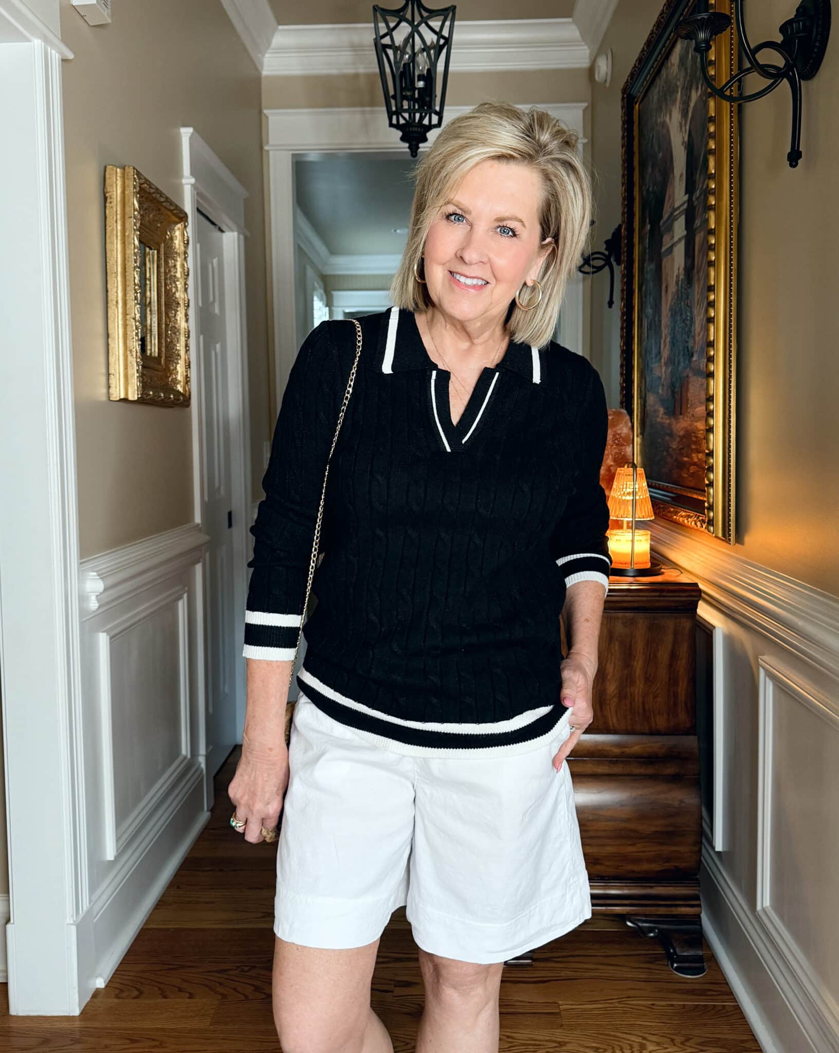 Tania Stephens is wearing a black cable knit sweater and Frank & Eileen white shorts