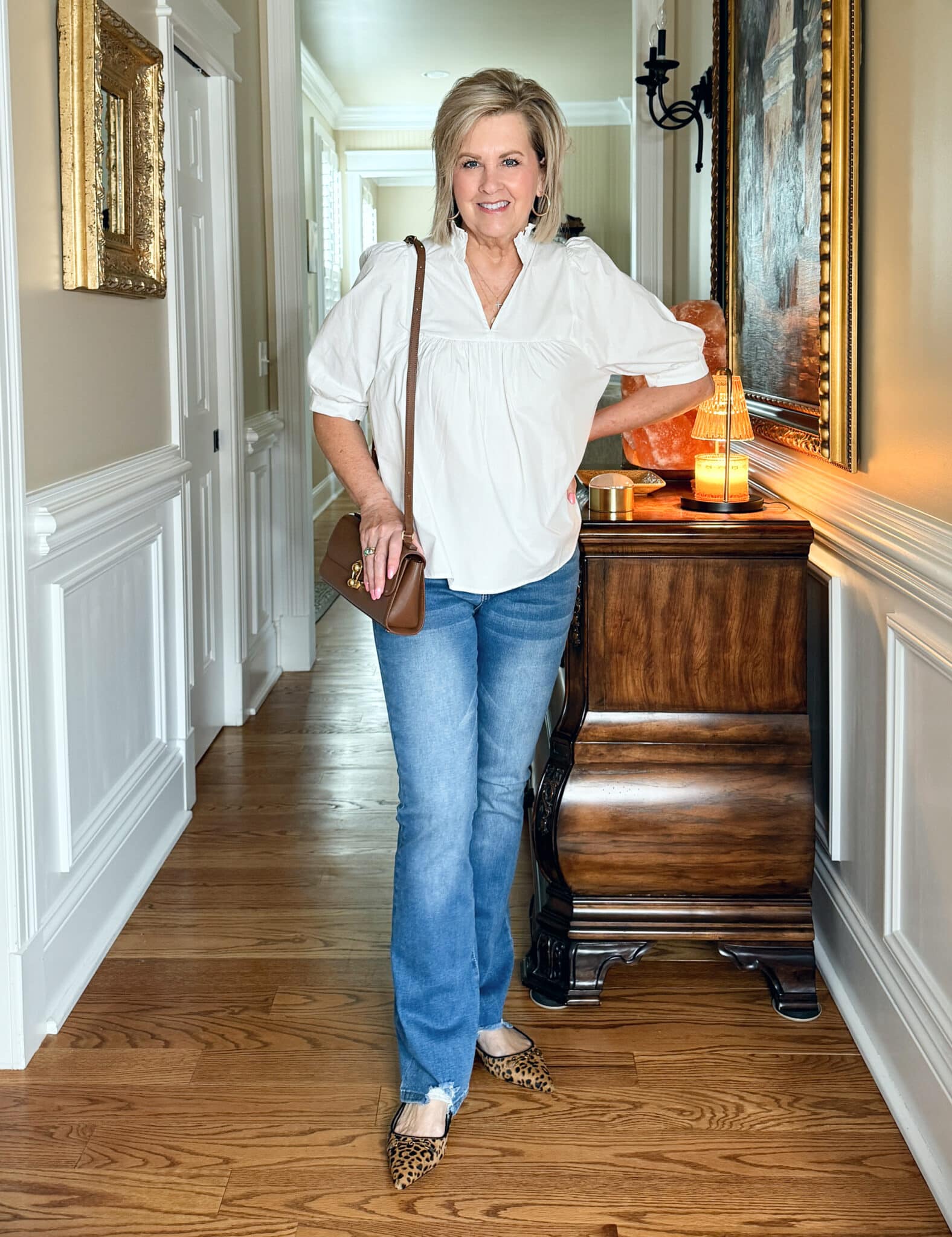 Tania Stephens is wearing a white top, jeans, and leopard print flats from Amazon