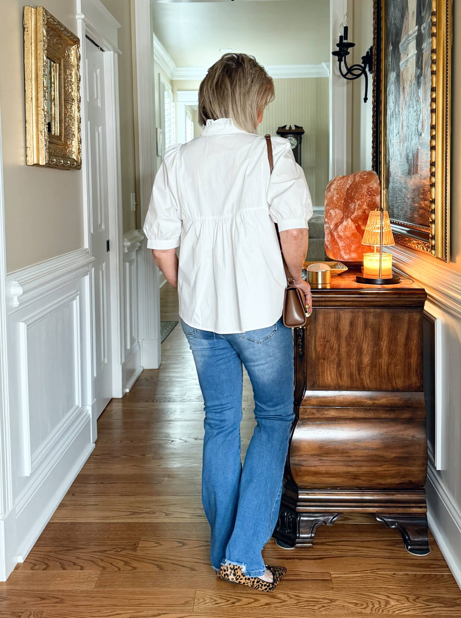 Tania Stephens is wearing a white top, jeans, and leopard print flats 
