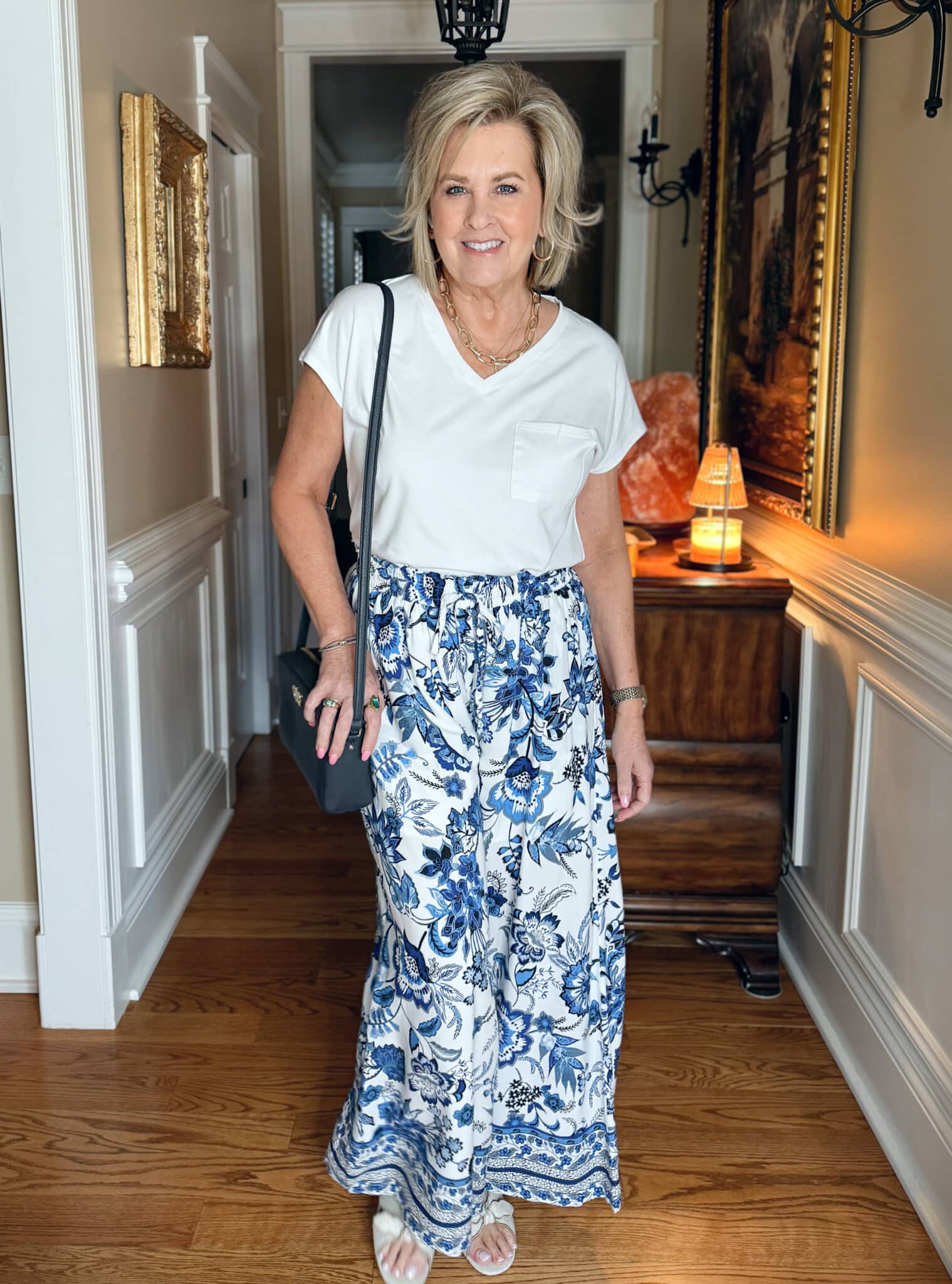 a woman in a white shirt and blue floral skirt