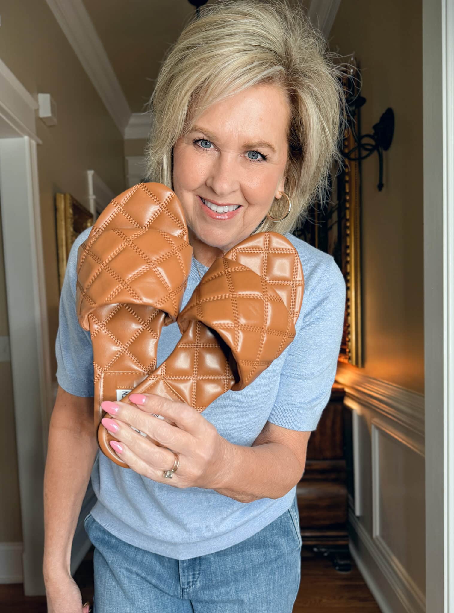 Tania Stephens is wearing a light blue sweater with woven sandals