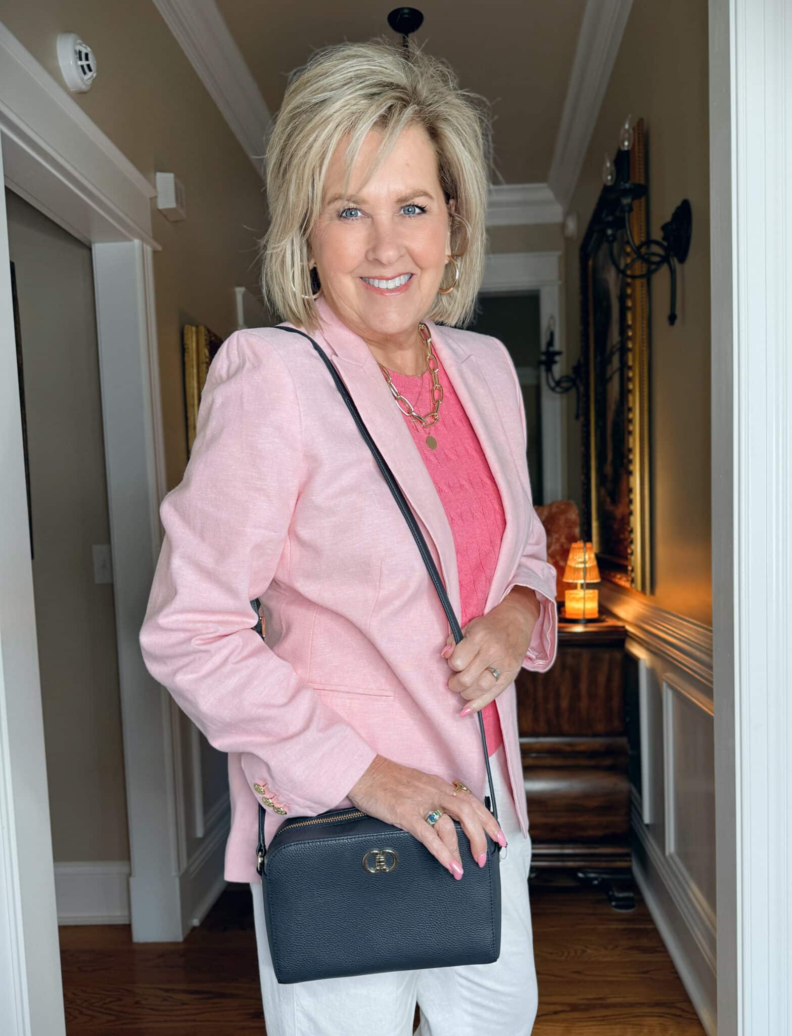 Tania Stephens is wearing a Pink blazer with a medium pink shell and a navy leather bag 